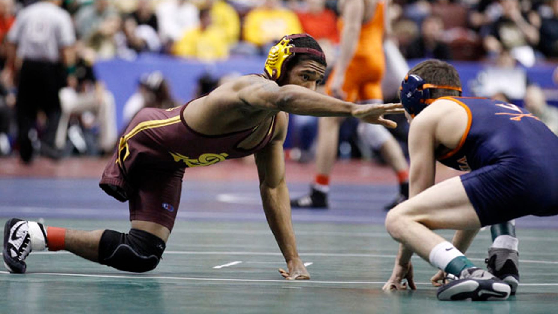 March 17, 2011: Arizona State's Anthony Robles, left, reaches for Virginia's Matthew Snyder during their 125-pound first round match at the NCAA Division I Wrestling Championships in Philadelphia.