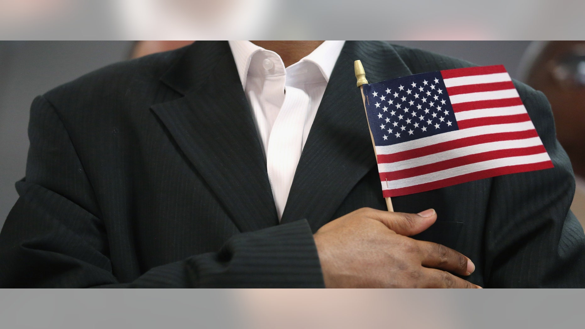 NEW YORK, NY - MAY 17: A new U.S. citizen stands while reciting the pledge of allegiance after becoming an American citizen at a naturalization ceremony held at the U.S. Citizenship and Immigration Services (USCIS), office on May 17, 2013 in New York City. One hundred and fifty immigrants from 38 different countries became U.S. citizens at the event. Some 11 million undocumented immigrants living in the U.S. stand to eventually gain American citizenship if Congress passes immigration reforms currently being negotiated in Washington D.C. (Photo by John Moore/Getty Images)