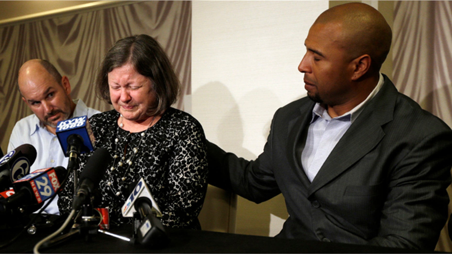 April 9, 2013: Former NFL player Dorsey Levens, right, extends a hand as Mary Ann Easterling, the widow of former NFL football player Ray Easterling, reacts as former NFL player Kevin Turner, left, looks on during a news conference in Philadelphia, after a hearing to determine whether the NFL faces years of litigation over concussion-related brain injuries. (AP/Matt Rourke, File)