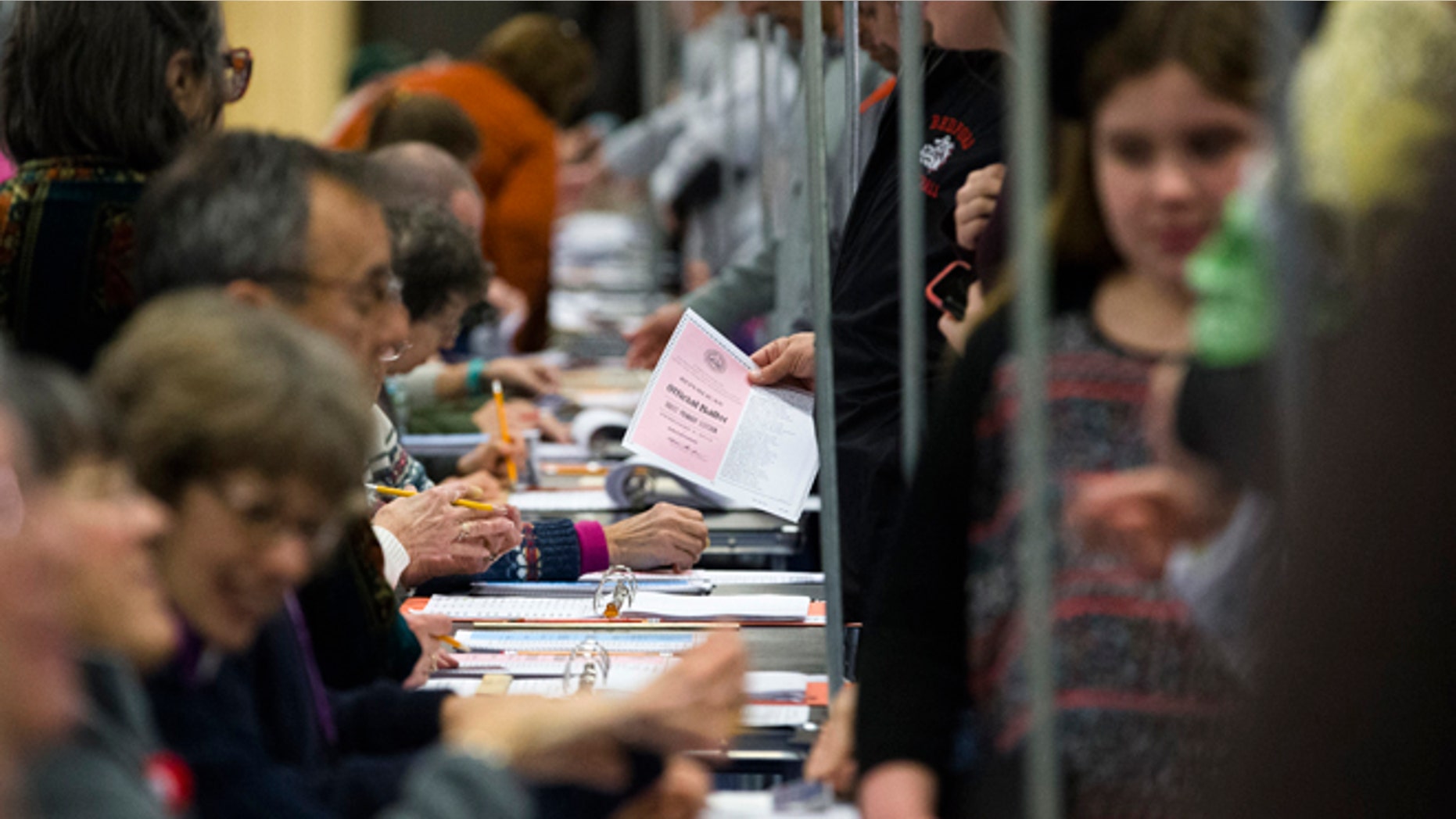 Voters collect their ballots at a polling place inside Bedford High School, Tuesday, Feb. 9, 2016, in Bedford, N.H. (AP Photo/John Minchillo)