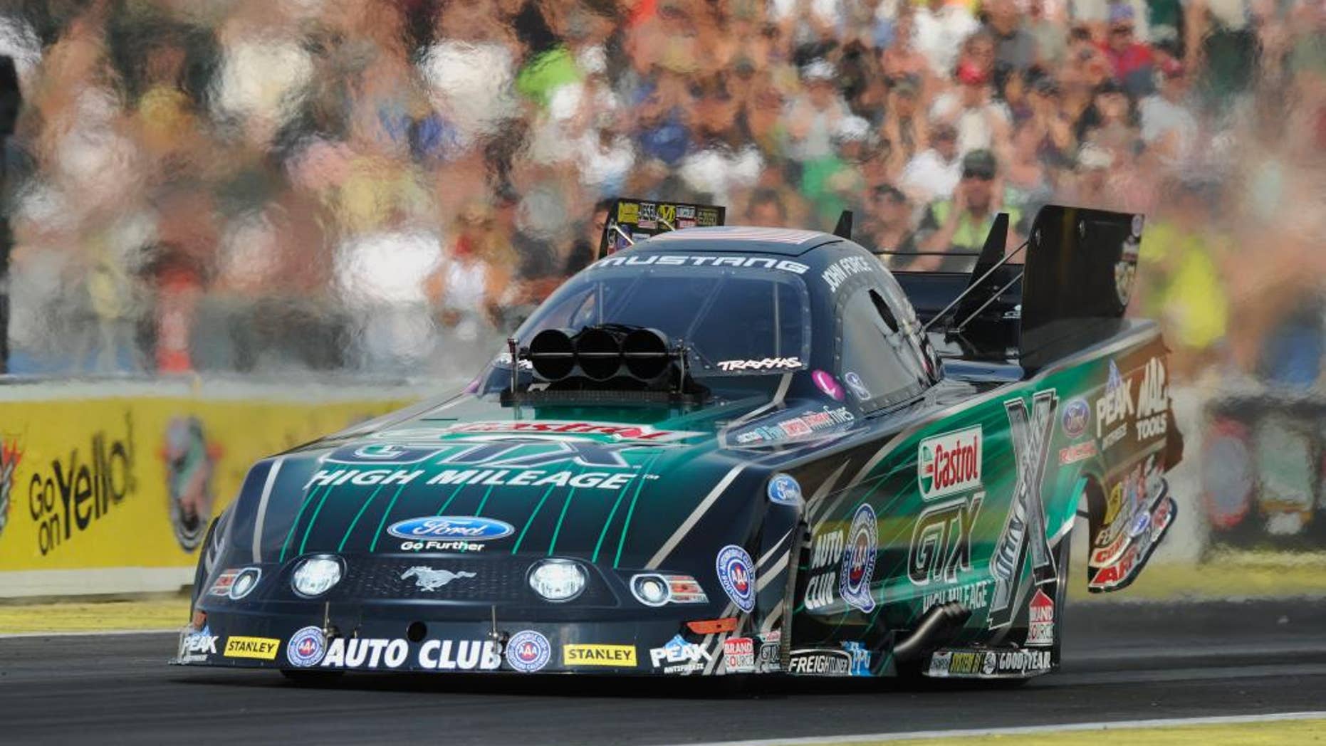 In this photo provided by NHRA, John Force drives in Funny Car qualifying Saturday, Aug. 2, 2014, at the O’Reilly Auto Parts NHRA Northwest Nationals drag races at Pacific Raceways in Kent, Wash. Force took the top spot with a run of 4.057 seconds at 308.07 mph. (AP Photo/NHRA, Jerry Foss)