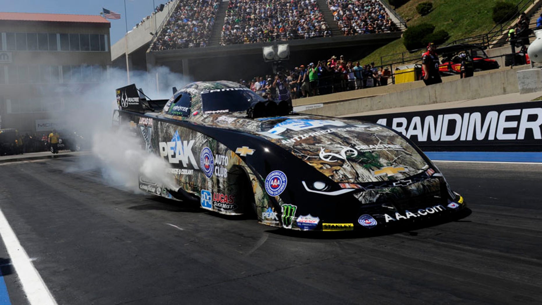 In this photo provided by NHRA, John Force prepares for a run in Funny Car during the Mopar Mile-High NHRA Nationals.