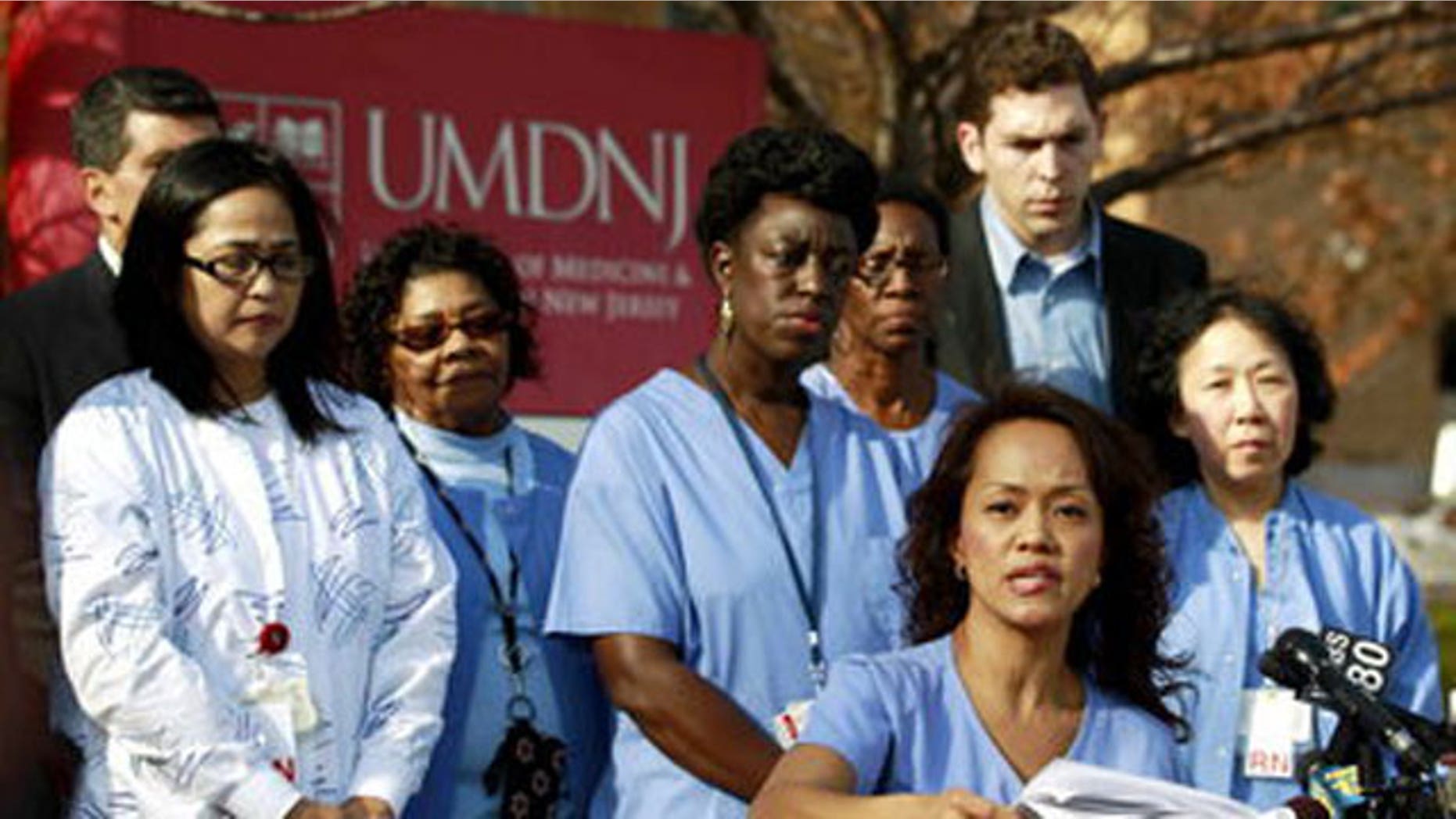 November 14, 2011: Fe Esperanza Racpan Vinoya, bottom, a registered nurse at the University of Medicine and Dentistry of New Jersey, talks during a news conference in Newark, N.J.