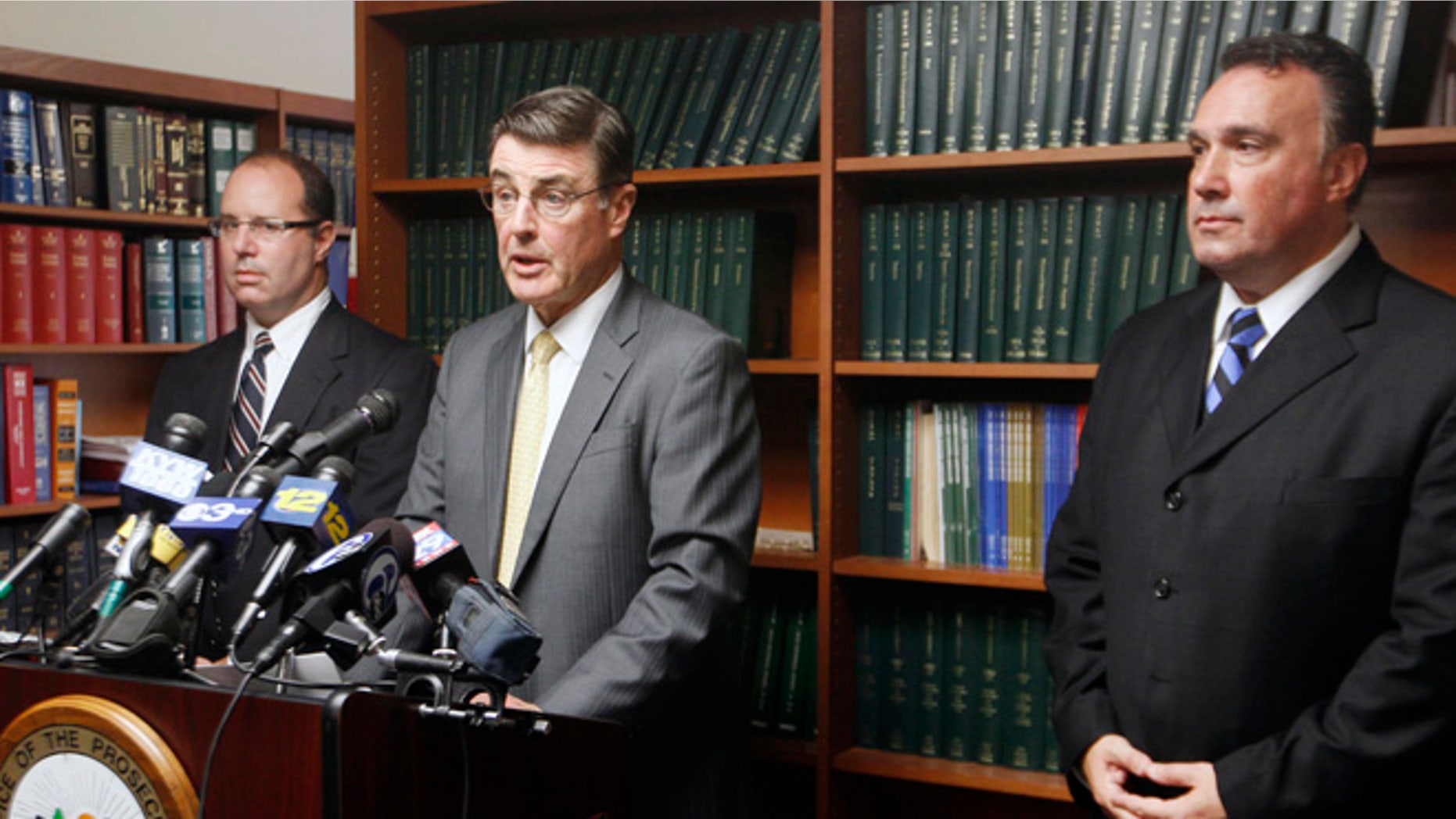 Oct. 4, 2012: Prosecutor's Office Sgt. Kevin Kellejan, right, and Mark Chase, section chief of the special prosecutor's unit, left, listen as Camden County Prosecutor Warren W. Faulk announcesin Camden, N.J., that three teachers and two administrators at a southern New Jersey high school have been arrested on charges stemming from allegations involving sex with students.