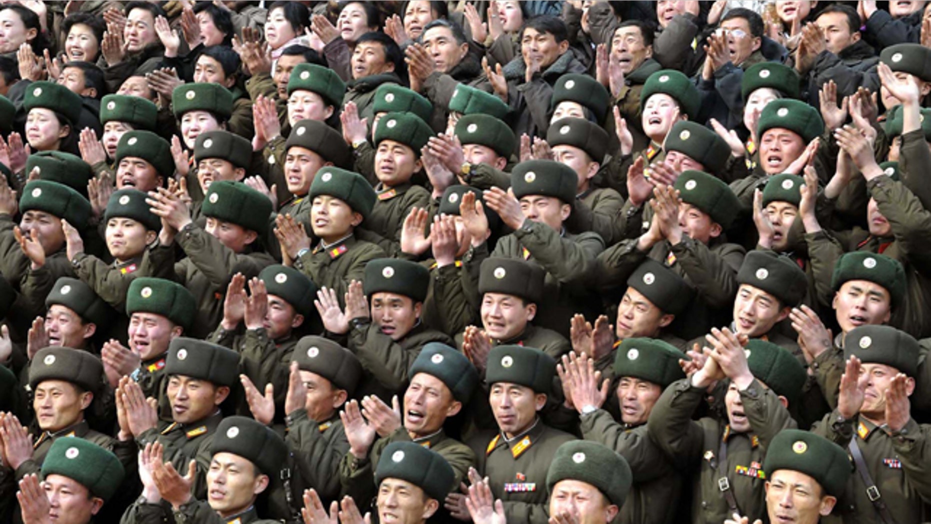 FILE - In this undated file photo released by the Korean Central News Agency and distributed in Tokyo by the Korea News Service on Jan. 21, 2012, military personnel clap as North Korean leader Kim Jong Un, unseen, visits the Korean People's Army (KPA) Unit 3870 at an undisclosed location in North Korea. Young Kim gets rock star treatment when he visits his troops, just as his father did. But while the late Kim Jong Il mostly stayed aloof in dark shades, his son holds hands and hugs. He seems to want to bond. (AP Photo/Korean Central News Agency via Korea News Service, File) JAPAN OUT UNTIL 14 DAYS AFTER THE DAY OF TRANSMISSION