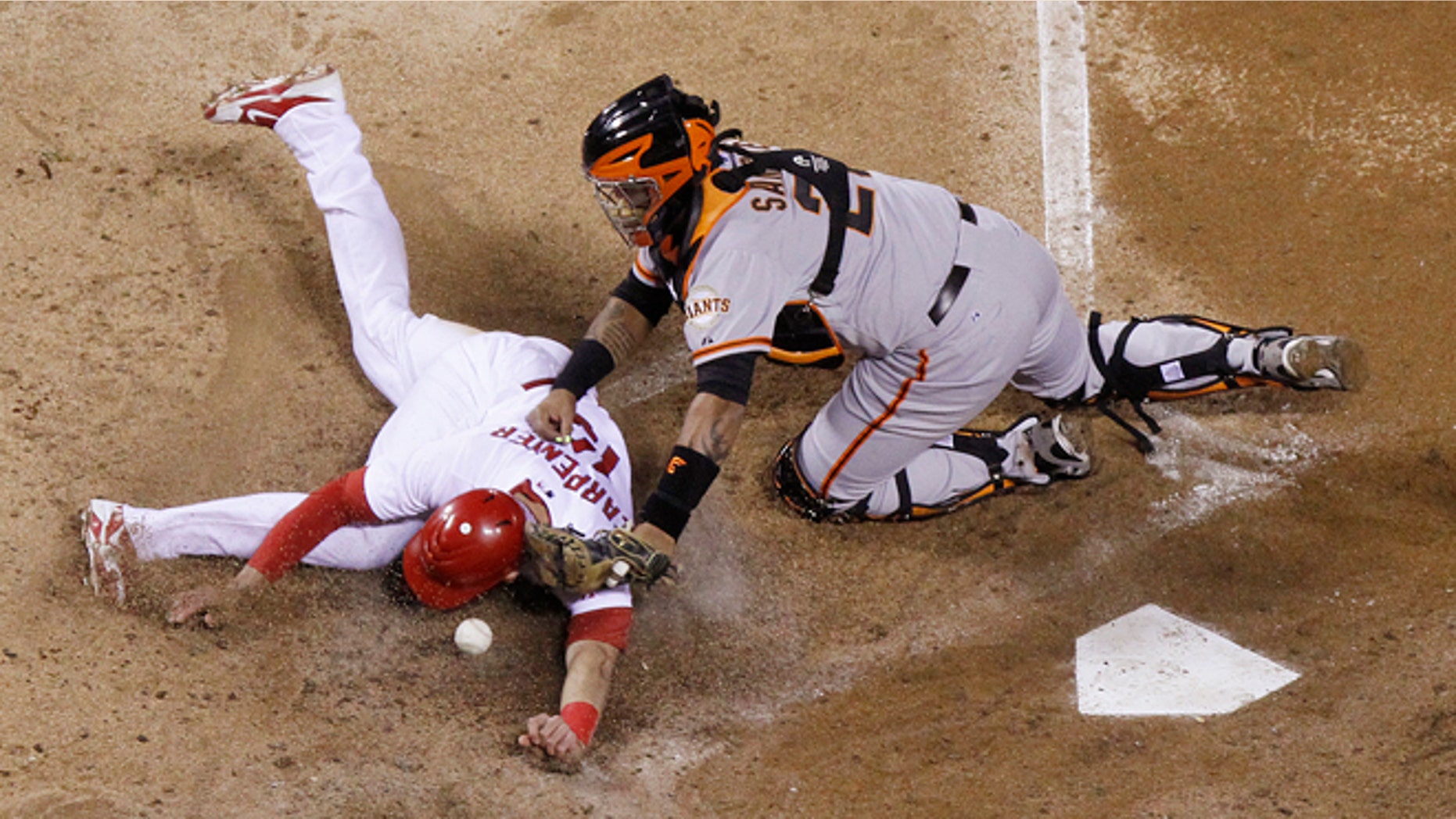 San Francisco catcher Hector Sanchez (right) is unable to handle the throw as Cardinals' Matt Carpenter slides towards home on a single by Matt Holliday in fifth inning action during Game 4 of the National League Championship Series.