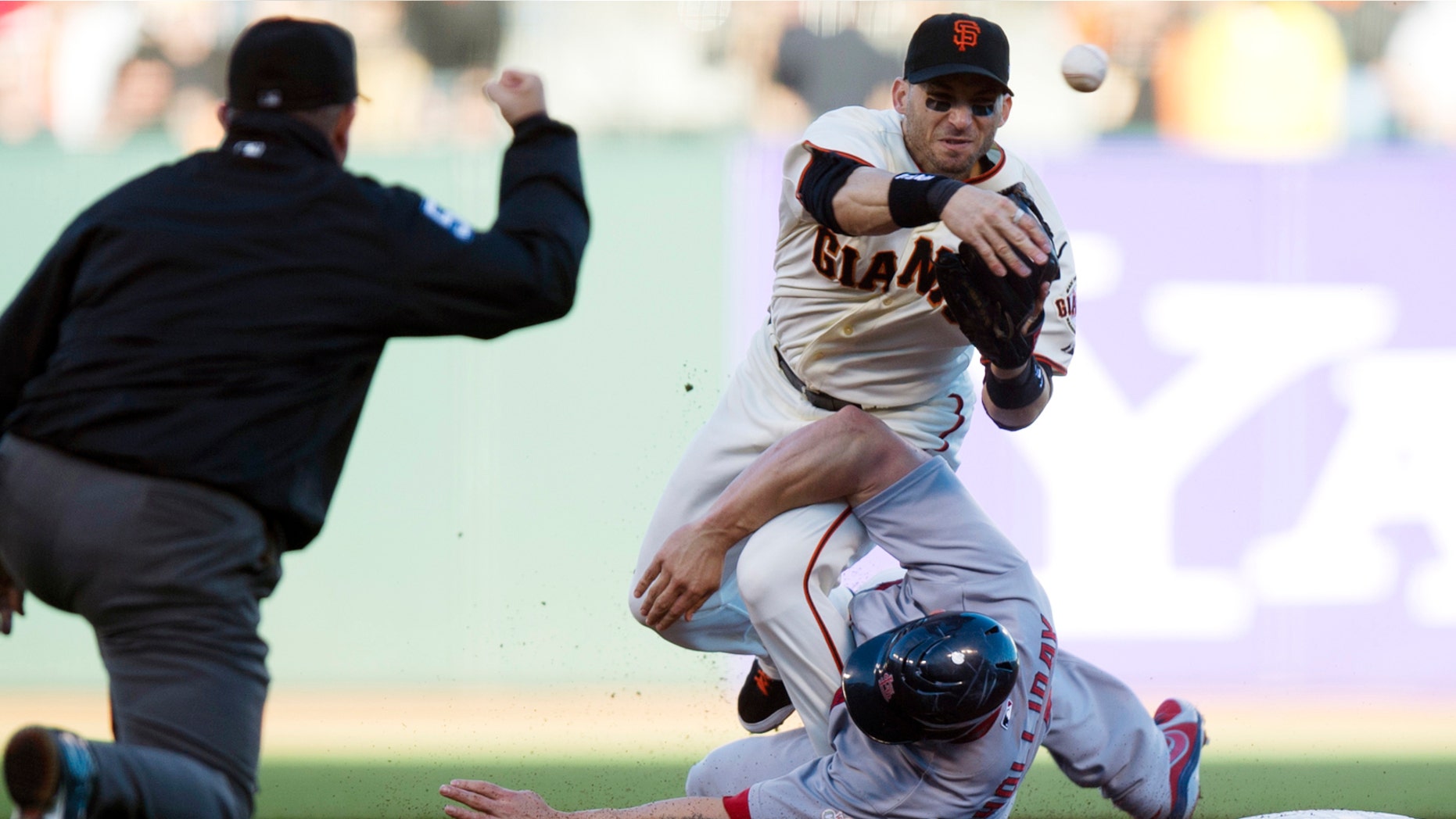 Oct. 15: San Francisco Giants second baseman Marco Scutaro (19) throws to first as he is taken out by St. Louis Cardinals' Matt Holliday (7) during Game 2 of NLCS.