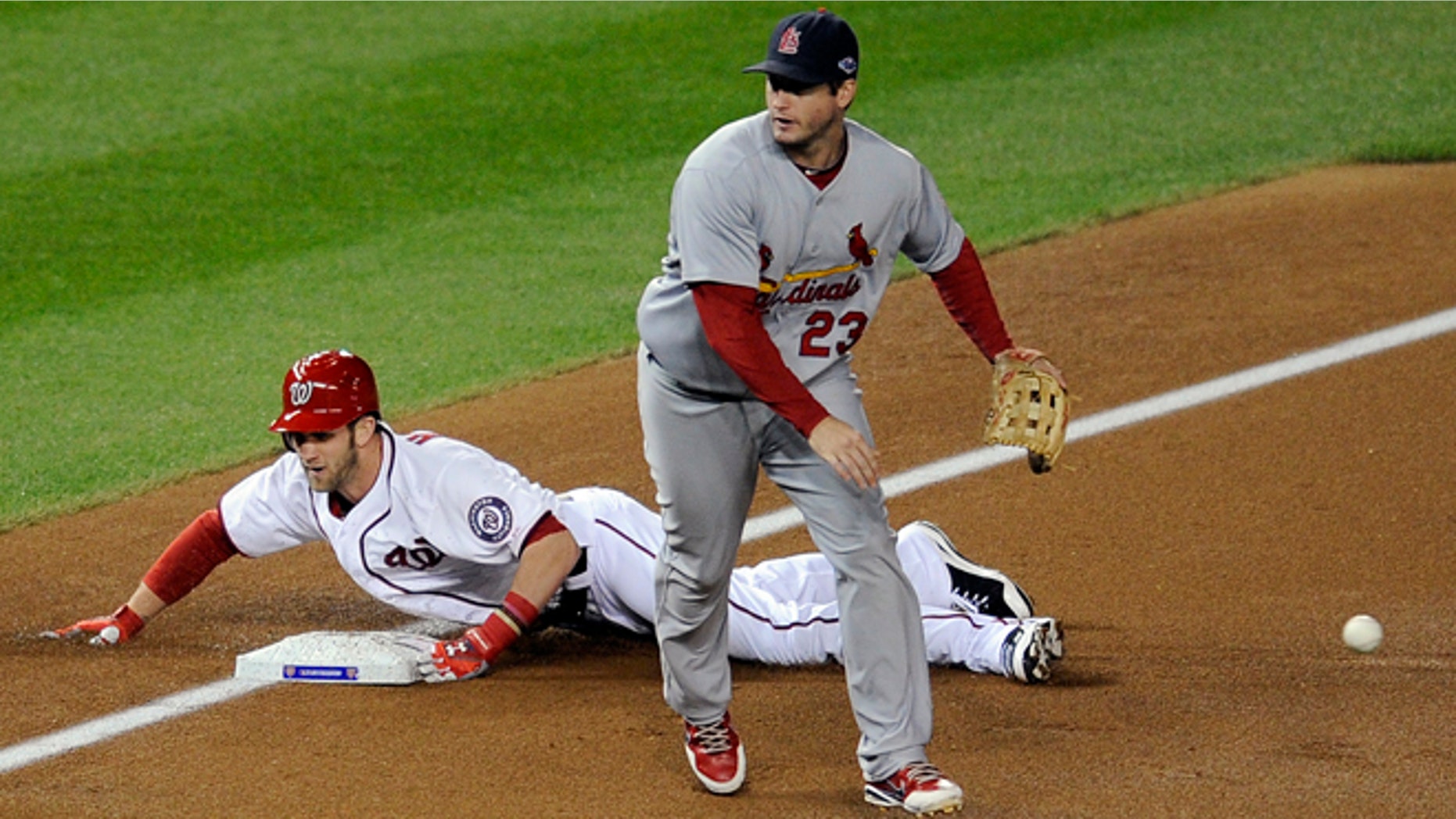 Oct. 12, 2012: Washington Nationals' Bryce Harper, back, slides into third base for a triple as the throw goes wide of St. Louis Cardinals third baseman David Freese in the first inning of Game 5 of the National League division baseball series in Washington.