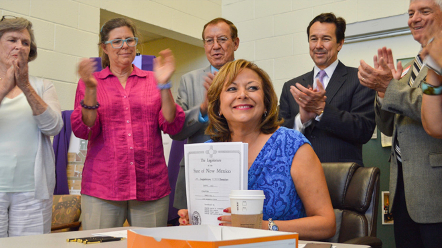 From left, New Mexico state Senator Mary Kay Papen, D-Las Cruces, Pamela Angell, executive director of St. Luke's Health Care Clinic, state Rep. Bealquin Gomez, D-La Mesa, Jon Barela, director of the New Mexico Economic Development Department, and state Senator Ron Griggs, R-Alamogordo applaud New Mexico Governor Susana Martinez, center, following the signing of a $294 million capital spending bill Wednesday, June 17, 2015, at St. Luke's Health Care Clinic in Las Cruces, New Mexico. St. Luke's was a recipient of $500,000 in capital outlay funds. (Anthony Albidrez/Las Cruces Sun-News via AP)