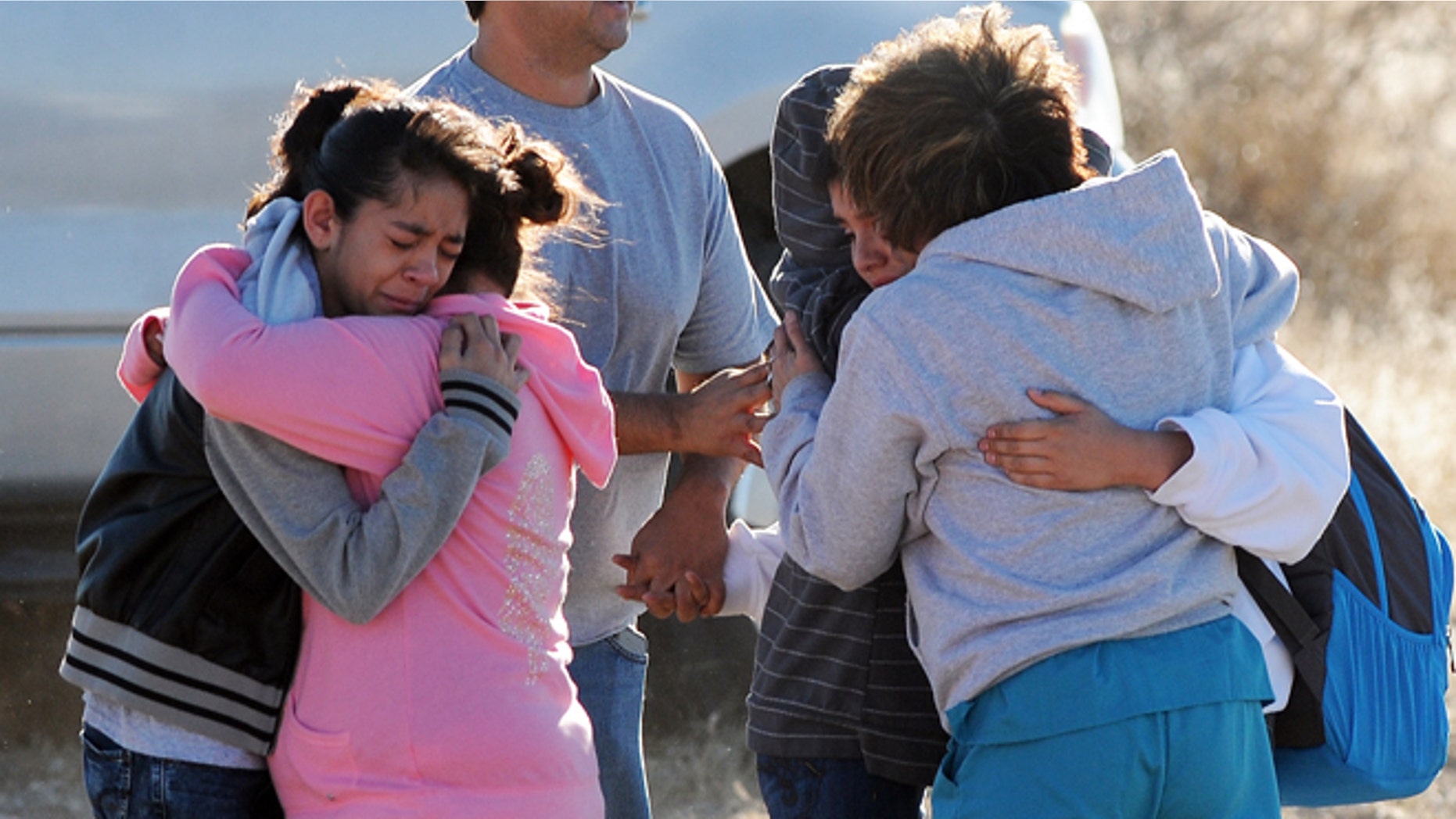 Students are reunited with family following a shooting at Berrendo Middle School, Tuesday, Jan. 14, 2014, in Roswell, N.M. Roswell police said the suspected shooter was arrested at the school, but authorities have not said if there were any injuries. The school has been placed on lockdown. No other details are yet available. (AP Photo/Roswell Daily Record, Mark Wilson)
