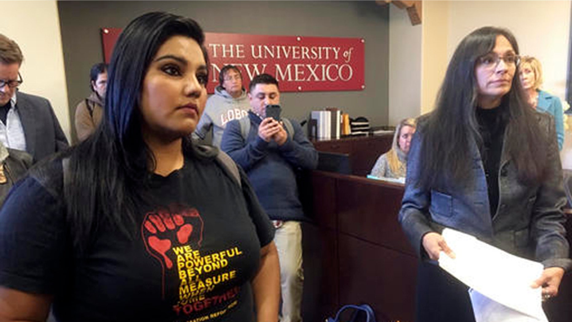 University of New Mexico student LuzHilda Campos, left, and Chicano studies professor Irene Vasquez, right, present a letter with hundreds of signatures on Friday, Nov. 18, 2016, to school president Bob Frank asking him to declare the campus a "sanctuary university," in Albuquerque, N.M. A group of professors at the largest university in the nation's most Hispanic state are asking for more protection of immigrant students following the election of Republican Donald Trump. (AP Photo/Russell Contreras)