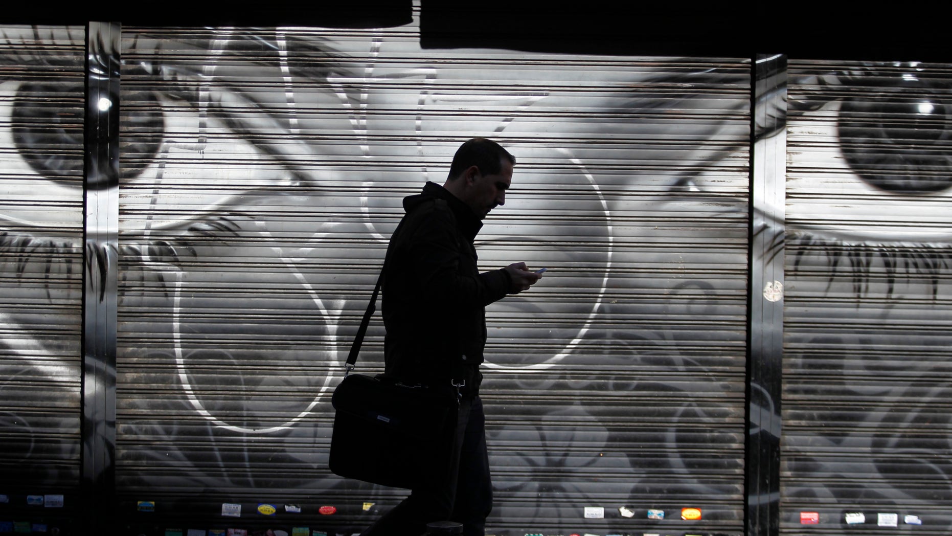 FILE - In this Thursday, Oct. 31, 2013, file photo, a man looks at his cellphone as he walks on the street in downtown Madrid. The National Security Agency tracks the locations of nearly 5 billion cellphones every day overseas, including those belonging to Americans abroad, The Washington Post reported Wednesday, Dec. 4, 2013. Such data means the NSA can track the movements of almost any cellphone around the world, and map the relationships of the cellphone user. (AP Photo/Francisco Seco, File)
