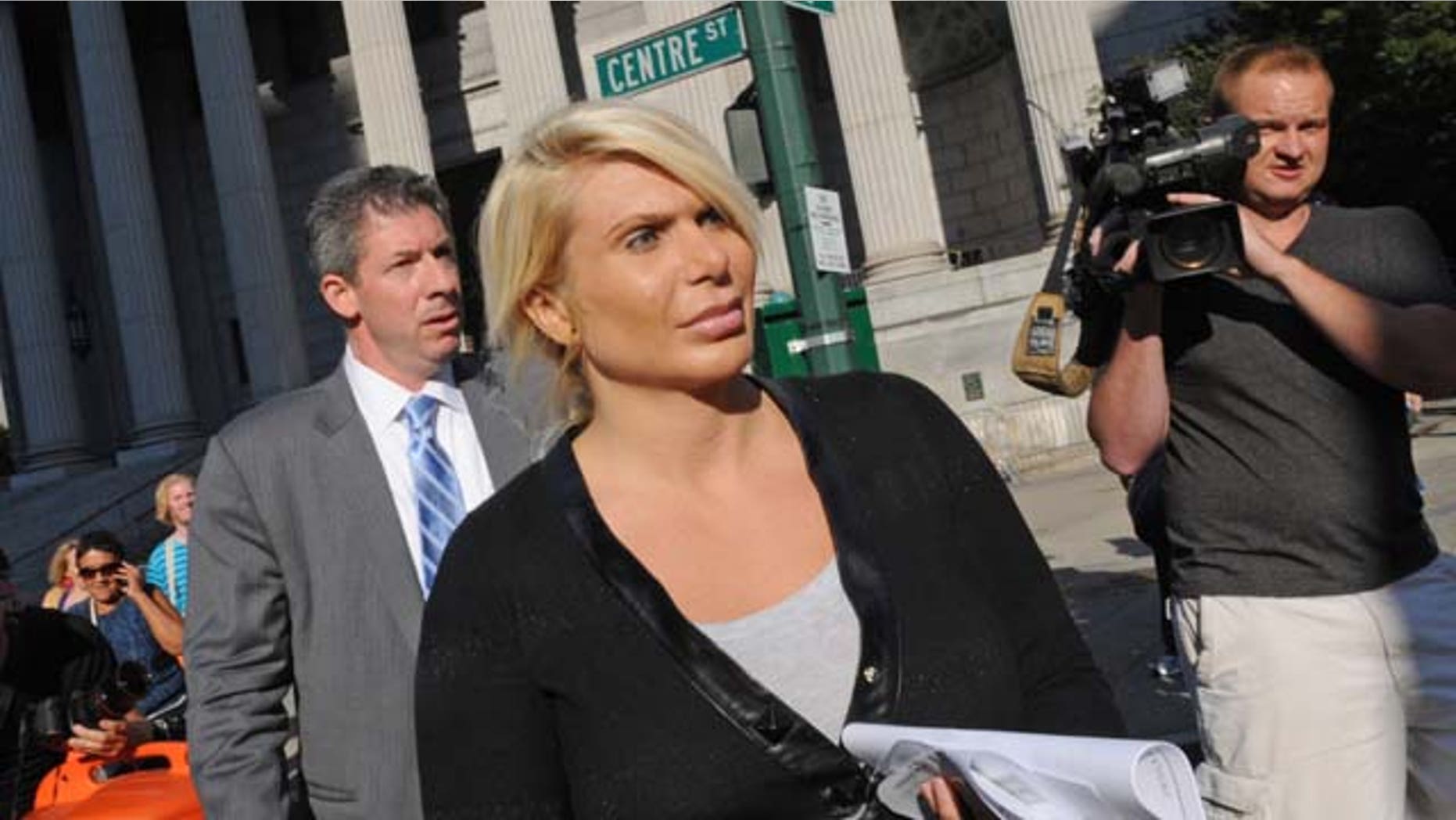 August 6, 2013: Kristin Davis, center, leaves Manhattan federal court with her attorney Daniel Hochheiser, left, in New York. Davis, a former madam running against former Gov. Eliot Spitzer in the race for New York City comptroller, peddled hundreds of powerful painkillers and other prescription pills in exchange for Ecstasy and cash from a drug dealer wearing a wire, federal authorities said Tuesday. (AP Photo)