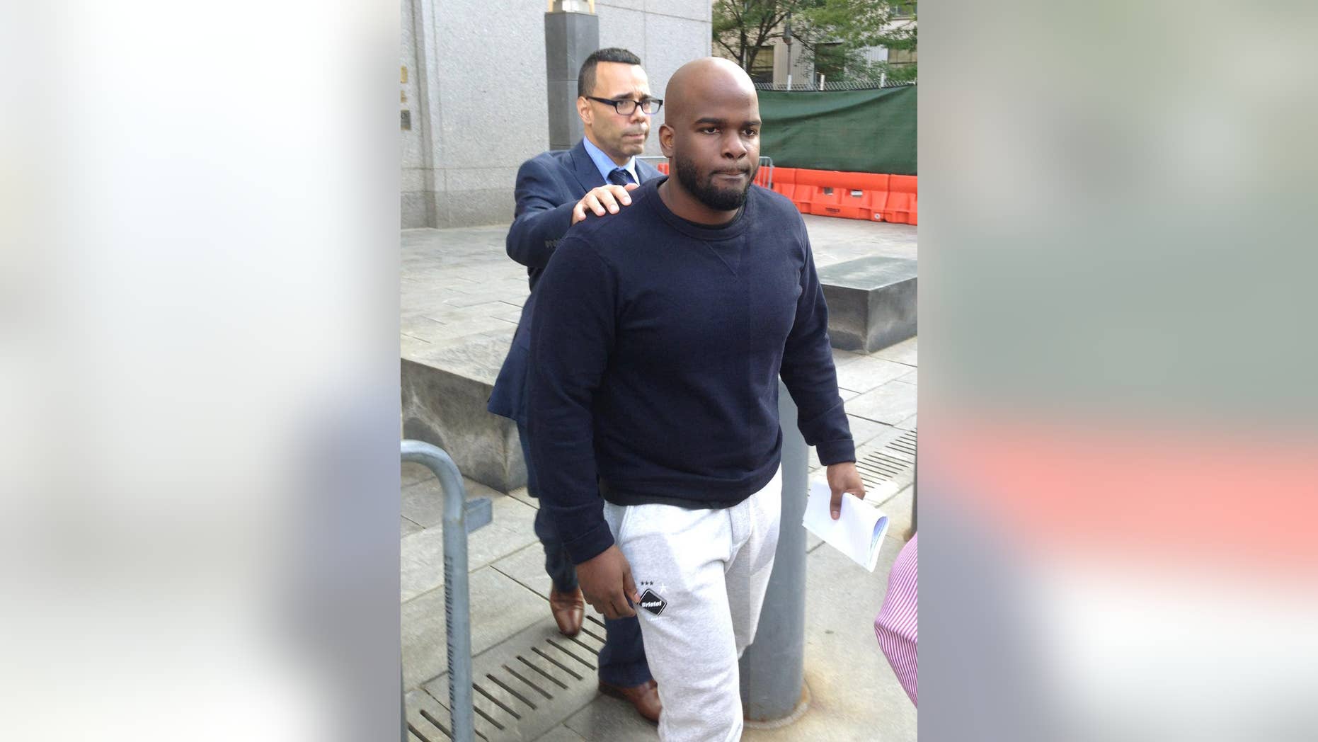 Byron Taylor, foreground, a guard at the Rikers Island jail, leaves court in New York, Wednesday, June 10, 2015 after his arraignment on conspiracy and obstruction charges for his part in a brutal assault on an inmate in 2012. Behind Taylor is his attorney Samuel Braverman. (AP Photo/Larry Neumeister)