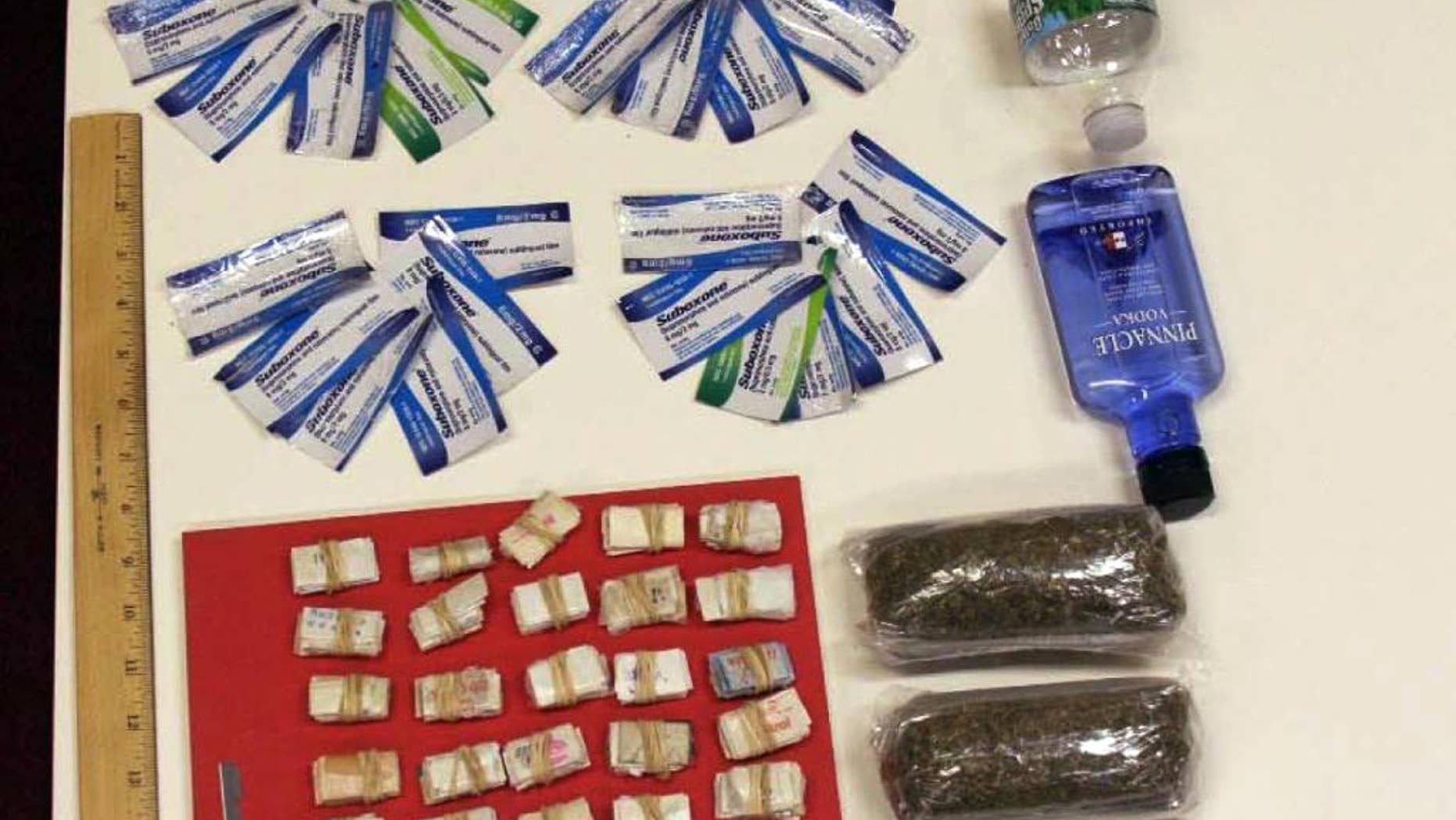 In this undated photo provided by the New York City Department of Investigation, contraband smuggled by an undercover investigator into Rikers Island jail facilities is shown. During six visits to the New York City jail, the investigator was able to get a plastic bag containing 250 glassine envelopes of heroin; one plastic bag containing 24 packaged strips of suboxone; two plastic bags containing a total weight of one half-pound of marijuana, 16 ounces of vodka in a water bottle, and one razor blade past the personnel at the security entrance. (AP Photo/New York City Department of Investigation)