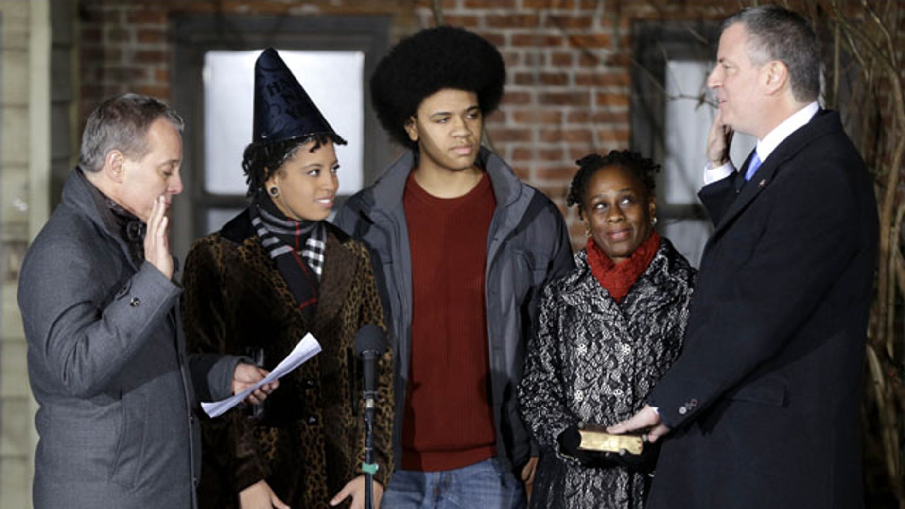 January 1, 2013: Bill de Blasio, right, is sworn in as the mayor of New York City by State Attorney General Eric Schneiderman, left, while his family, Chiara de Blasio, second from left, Dante de Blasio, center, and Chirlane McCray look on. De Blasio took the oath of office moments after midnight at his home in Park Slope, Brooklyn. (AP Photo)