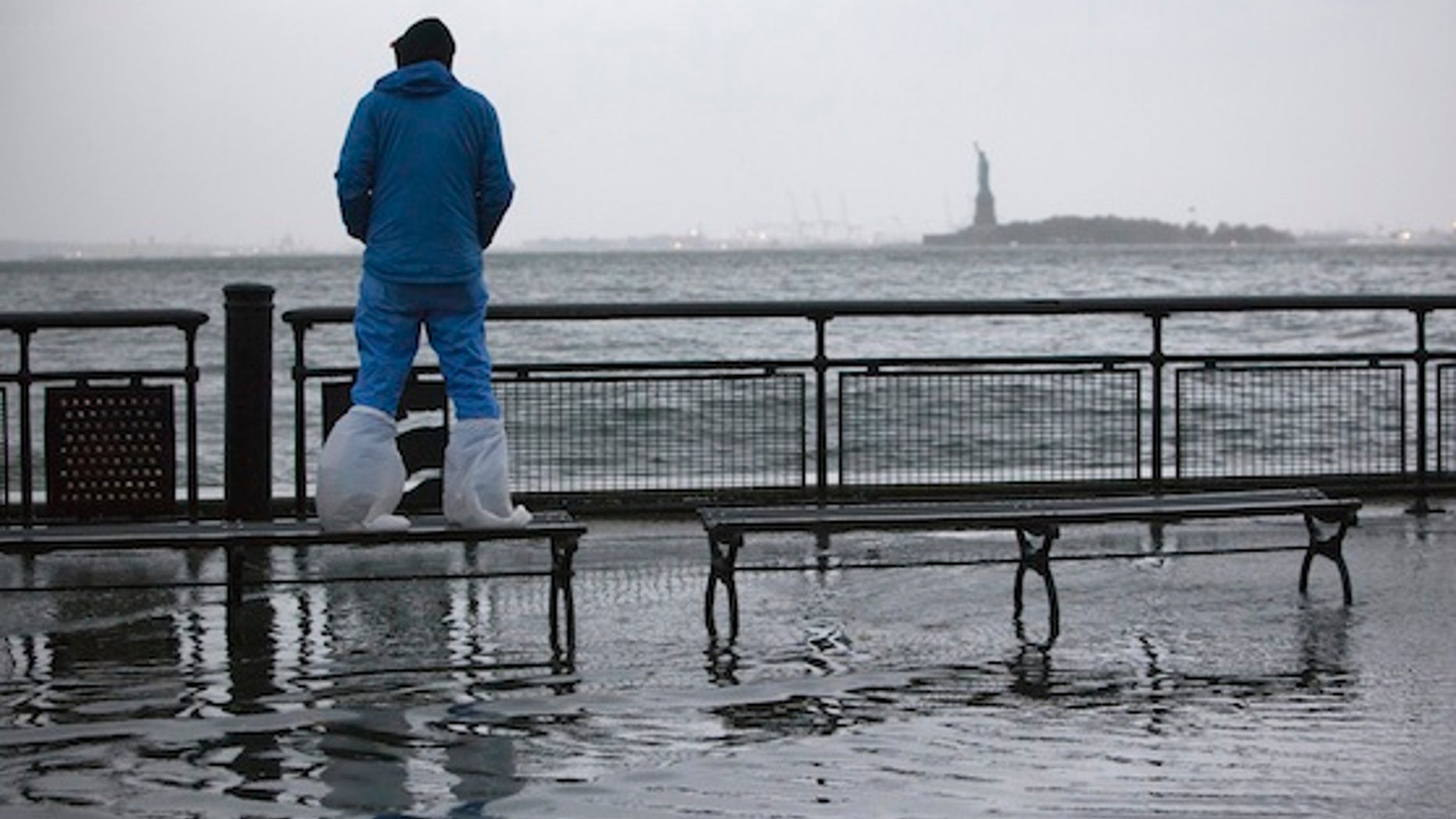 A man watches the rising tides in Battery Park as Hurricane Sandy makes its approach in New York October 29, 2012. Hurricane Sandy, the monster storm bearing down on the U.S. East Coast, strengthened on Monday after hundreds of thousands moved to higher ground, public transport shut down and the U.S. stock market suffered its first weather-related closure in 27 years. REUTERS/Andrew Kelly (UNITED STATES - Tags: ENVIRONMENT DISASTER)