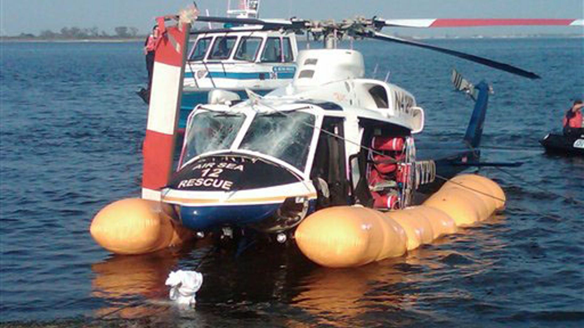 In this photo released by the New York City Police Department, a damaged NYPD helicopter is towed off Jamaica Bay after making an emergency landing, Wednesday, Sept. 22, 2010, in New York. The helicopter sustained a broken rotor and damaged windshield but the three-member flight crew, a trainee and two scuba divers escaped serious harm. One person was treated for a minor injury.