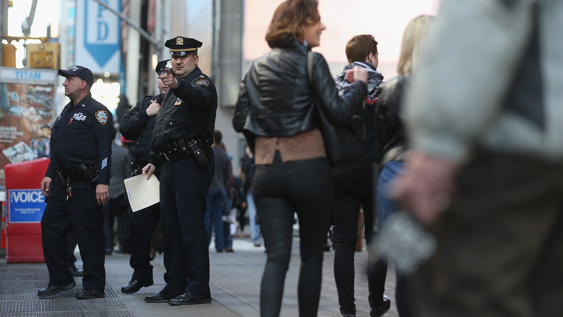 NEW YORK, NY - APRIL 15: New York Police Department officers gather at the edge of Times Square in Manhattan on April 15, 2013 in New York City. The city has announced it will implement heightened security measures in response to today's bombings at the Boston Marathon. (Photo by Mario Tama/Getty Images)