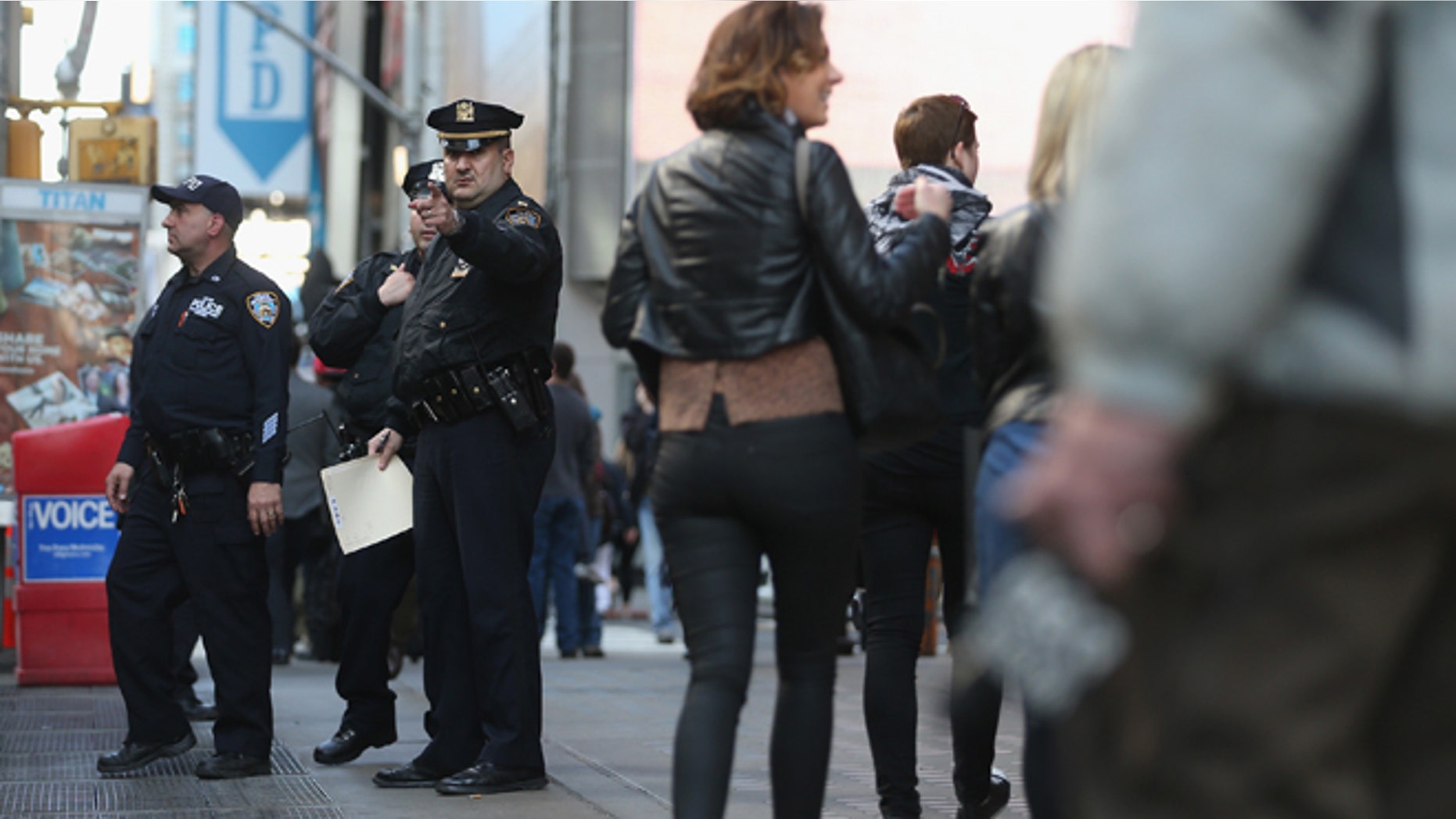 NEW YORK, NY - APRIL 15: New York Police Department officers gather at the edge of Times Square in Manhattan on April 15, 2013 in New York City. The city has announced it will implement heightened security measures in response to today's bombings at the Boston Marathon. (Photo by Mario Tama/Getty Images)