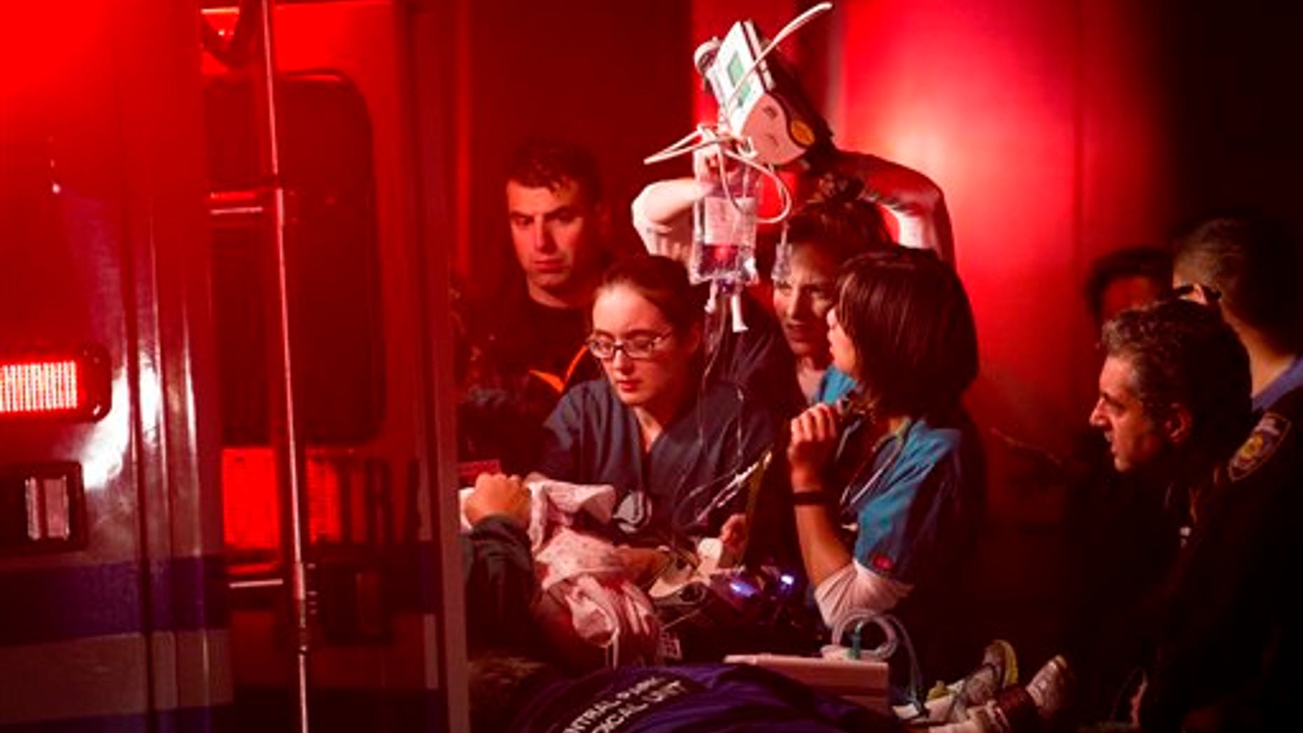 Medical workers assist a patient into an ambulance during an evacuation of NYU Langone Medical Center during Superstorm Sandy.