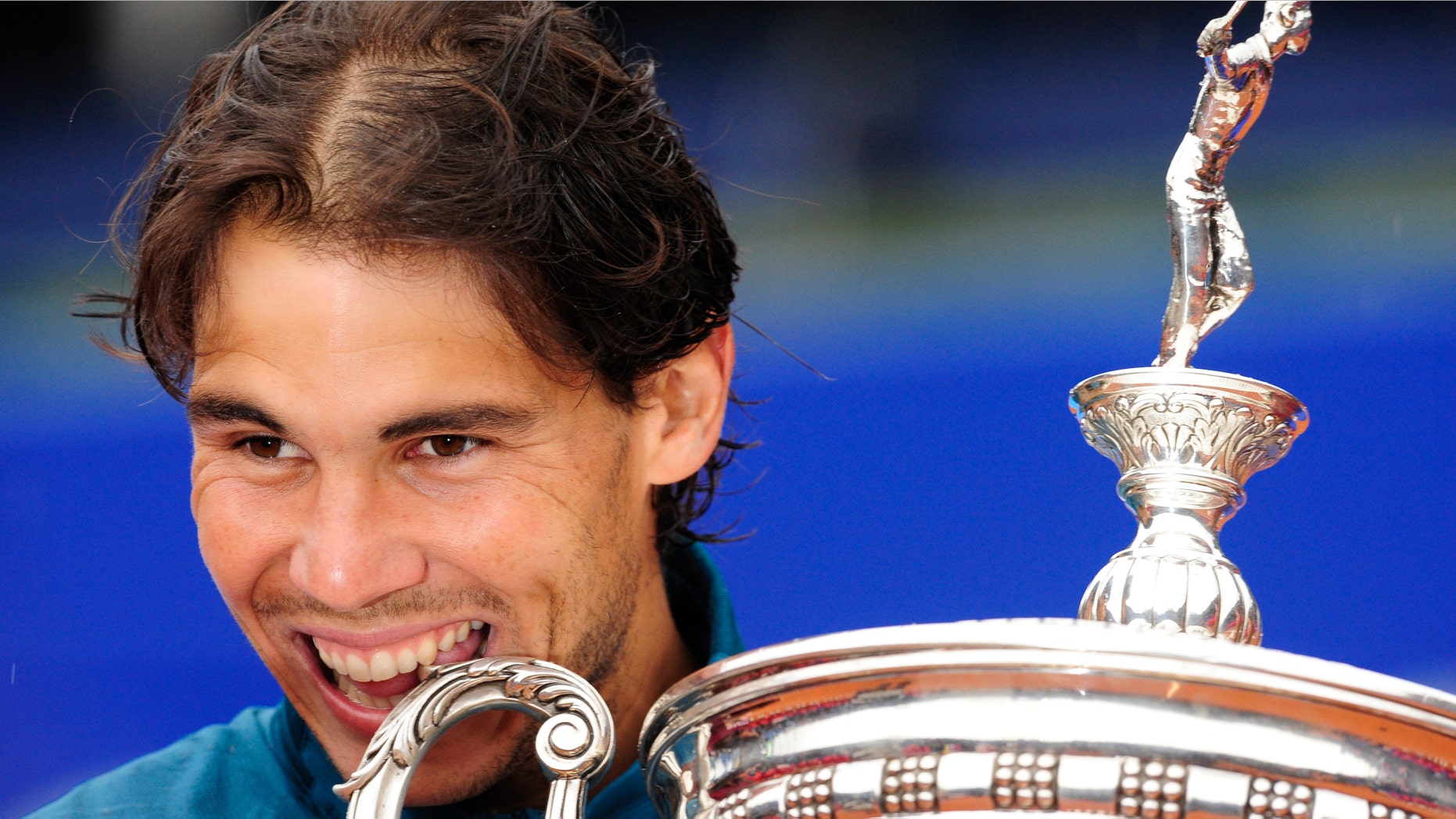 Rafael Nadal of Spain bites the trophy after his victory over Nicolas Almagro during the Barcelona final open tennis in Barcelona, Spain, Sunday, April 28, 2013. Nadal won 6-4, 6-3. (AP Photo/Manu Fernandez)