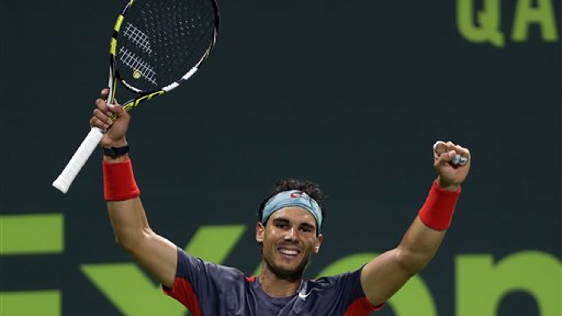 Spain's Rafael Nadal celebrates after winning the final match of the Qatar Open tournament in Doha against France's Gael Monfils on Saturday, Jan. 4, 2014. (AP Photo/Osama Faisal)