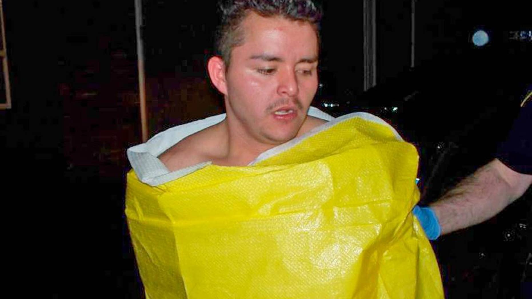 In this photo released by the Keizer, Ore., Police Department, 24-year-old Guillermo Brambila Lopez, of Woodburn, Ore., is wrapped in a blanket following his arrest, Sunday, Jan. 4, 2015. Police said Lopez broke into two homes in Keizer, drinking alcohol and using the hot tub at one of them. (AP Photo/Keizer Police Department)