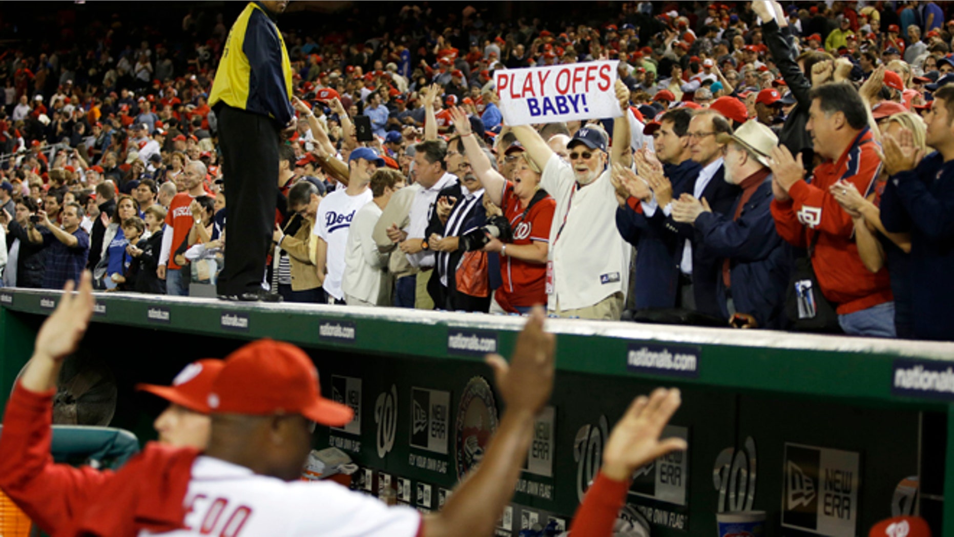 Washington Nationals players high-five as fans celebrate their 4-1 win against the Los Angeles Dodgers to clinch a playoff spot after their baseball game at Nationals Park in Washington, Thursday, Sept. 20, 2012. (AP Photo/Jacquelyn Martin)