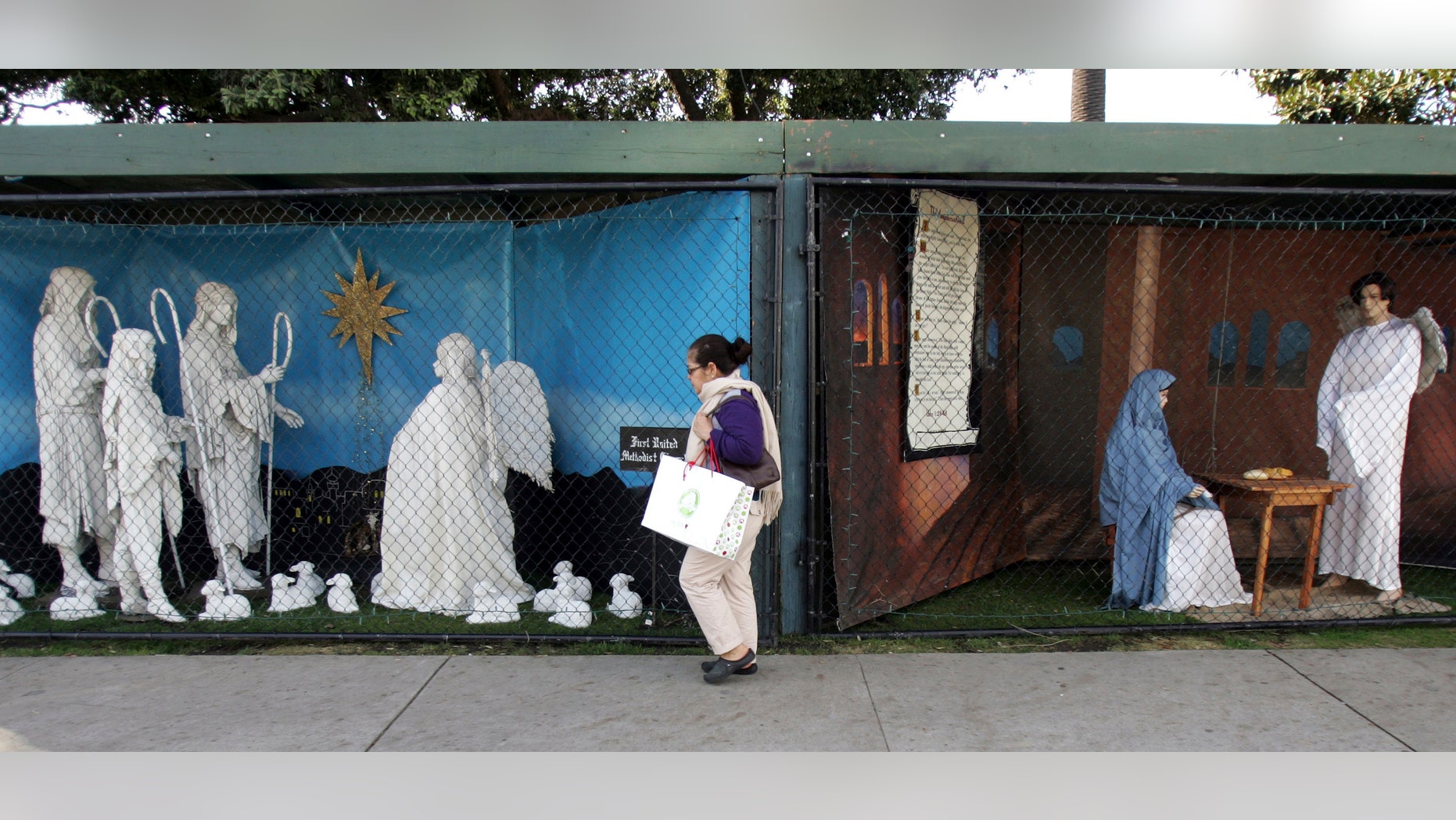 Dec. 13, 2011: A woman walks past a two of the traditional displays showing the Nativity scene along Ocean Avenue at Palisades Park in Santa Monica, Calif.