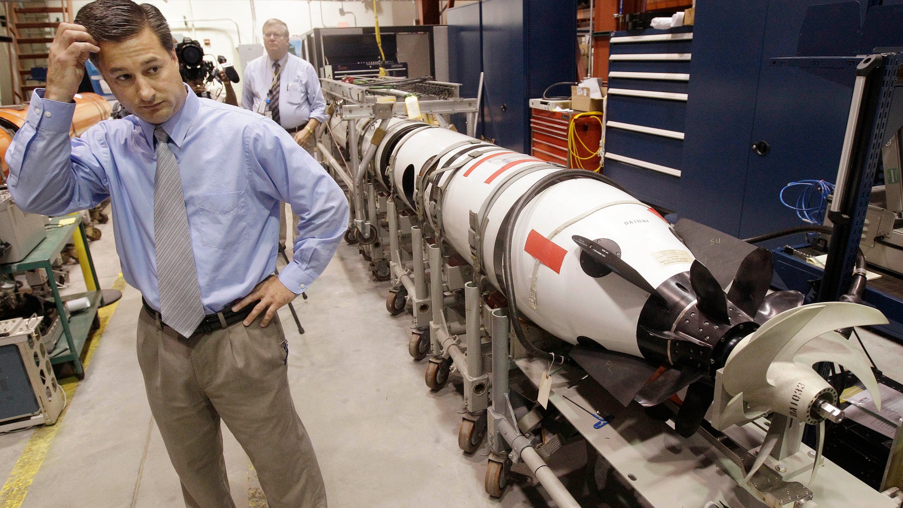 July 31, 2012: Christopher Del Mastro, head of anti submarine warfare mobil targets stands next to an unmanned underwater vehicle (UUV) in a lab at the Naval Undersea War Center in Middletown, RI.