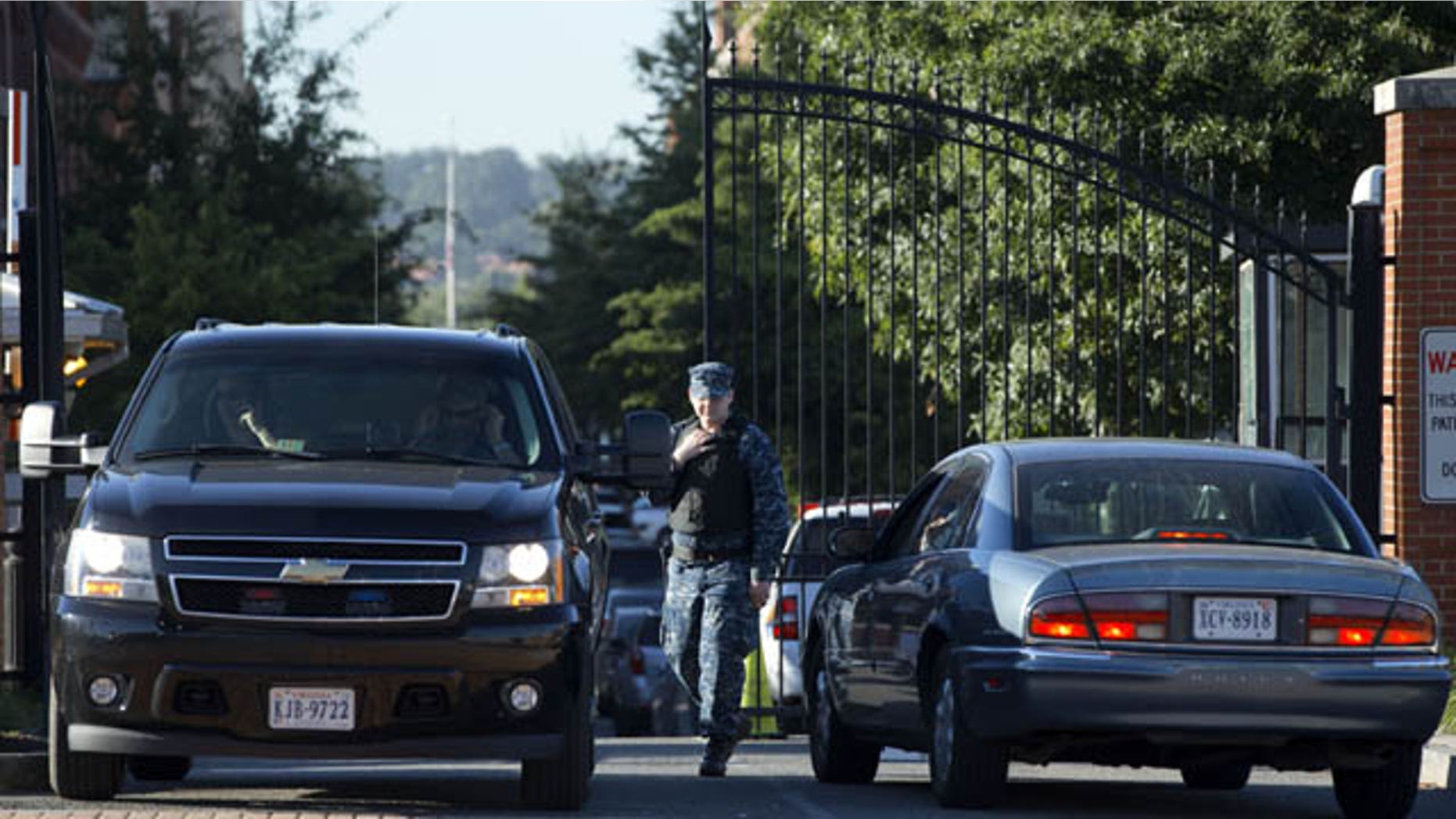 September 18, 2013: A member of the Navy checks vehicles at a gate to the Washington Navy Yard, as some employees return, many to retrieve their vehicles, two days after a gunman killed twelve people and was killed himself inside the Navy Yard. (AP Photo)