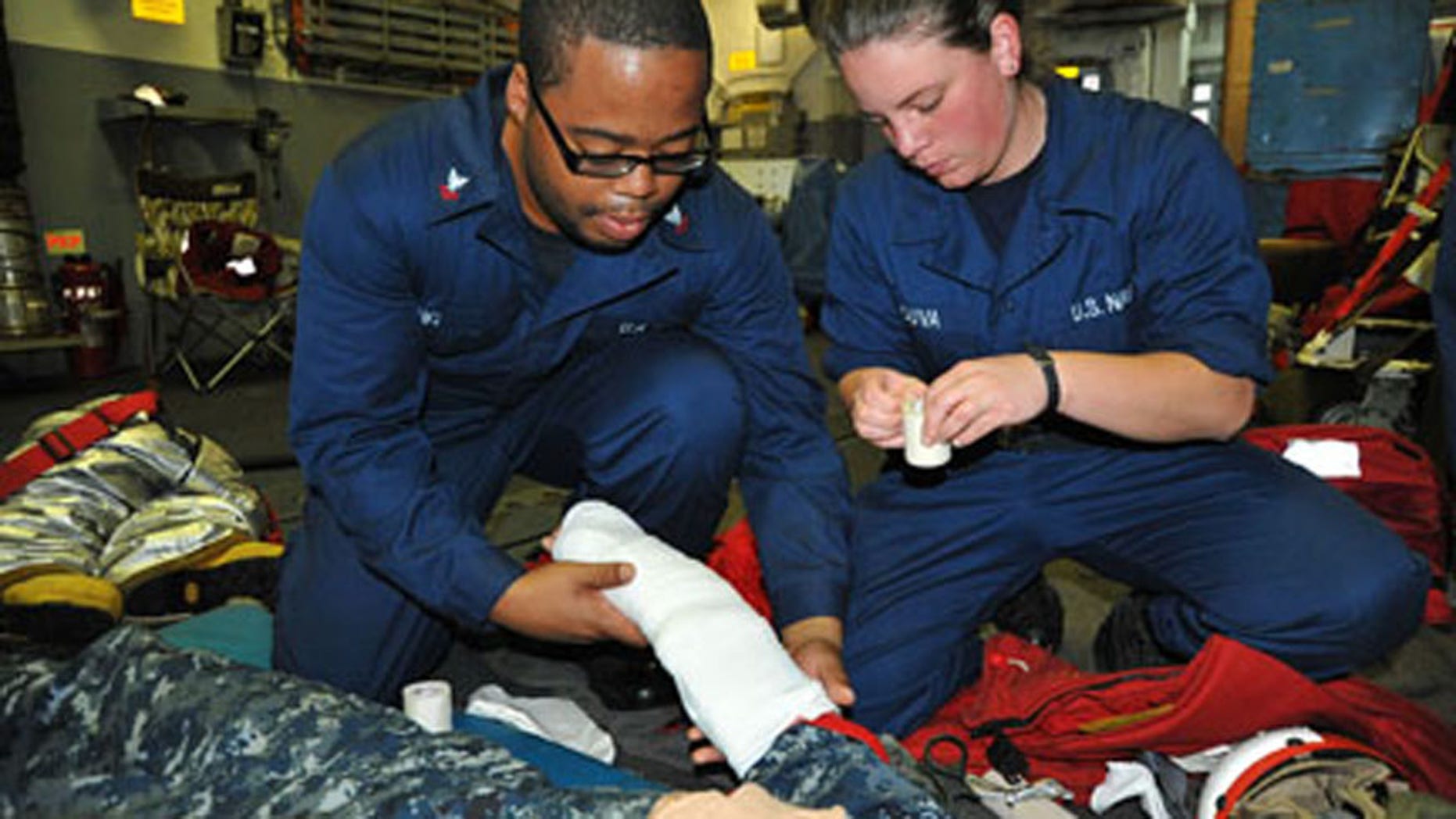 Yeoman 2nd Class Warren Ewing and Sonar Technician (Surface) Seaman Kelly Souva, both assigned to the Arleigh Burke-class guided-missile destroyer USS McCampbell (DDG 85), respond to a simulated medical casualty during a general quarters drill at sea.