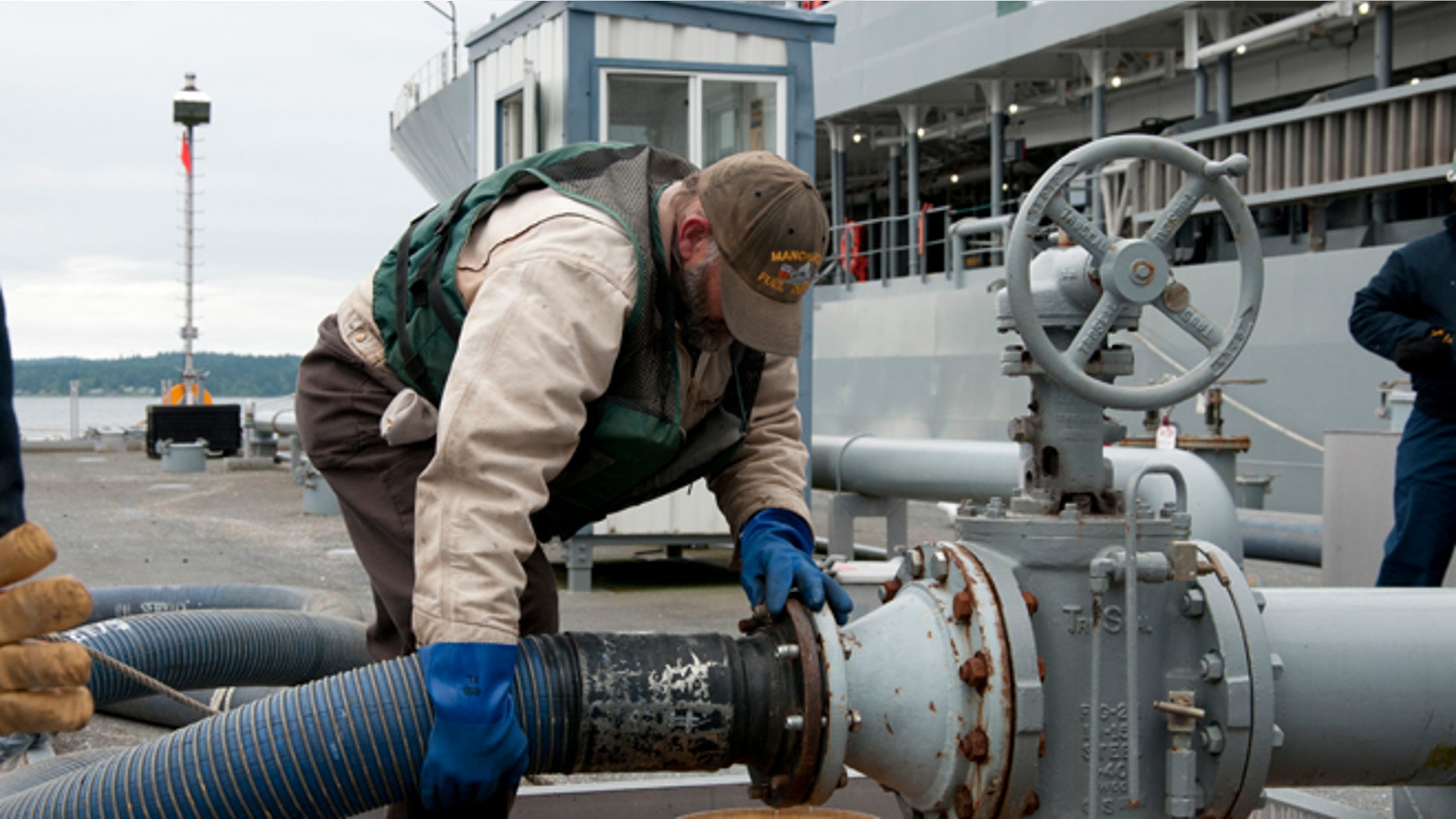 June 13, 2012. A Navy fuell specialist David Riggs secures a hose during a biofuels transfer to oiler USNS Henry J. Kaiser.
