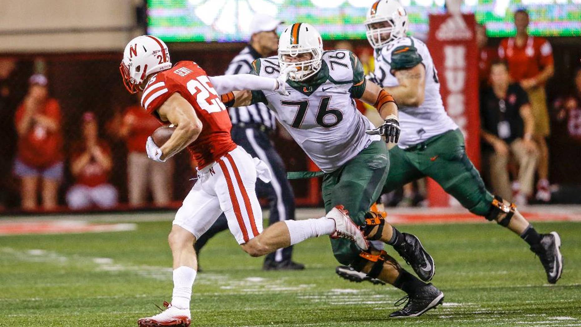 FILE - In this file photo from Sept. 20, 2014, Nebraska defensive back Nate Gerry (25) runs away from Miami offensive lineman Taylor Gadbois (76) after intercepting the ball in the second half of an NCAA college football game in Lincoln, Neb. Nebraska’s Gerry is back at safety and loving it. The sophomore, who played linebacker last season, is playing at an All-Big Ten level in the secondary, with interceptions in four of the Cornhuskers’ five conference games. (AP Photo/Nati Harnik, File)