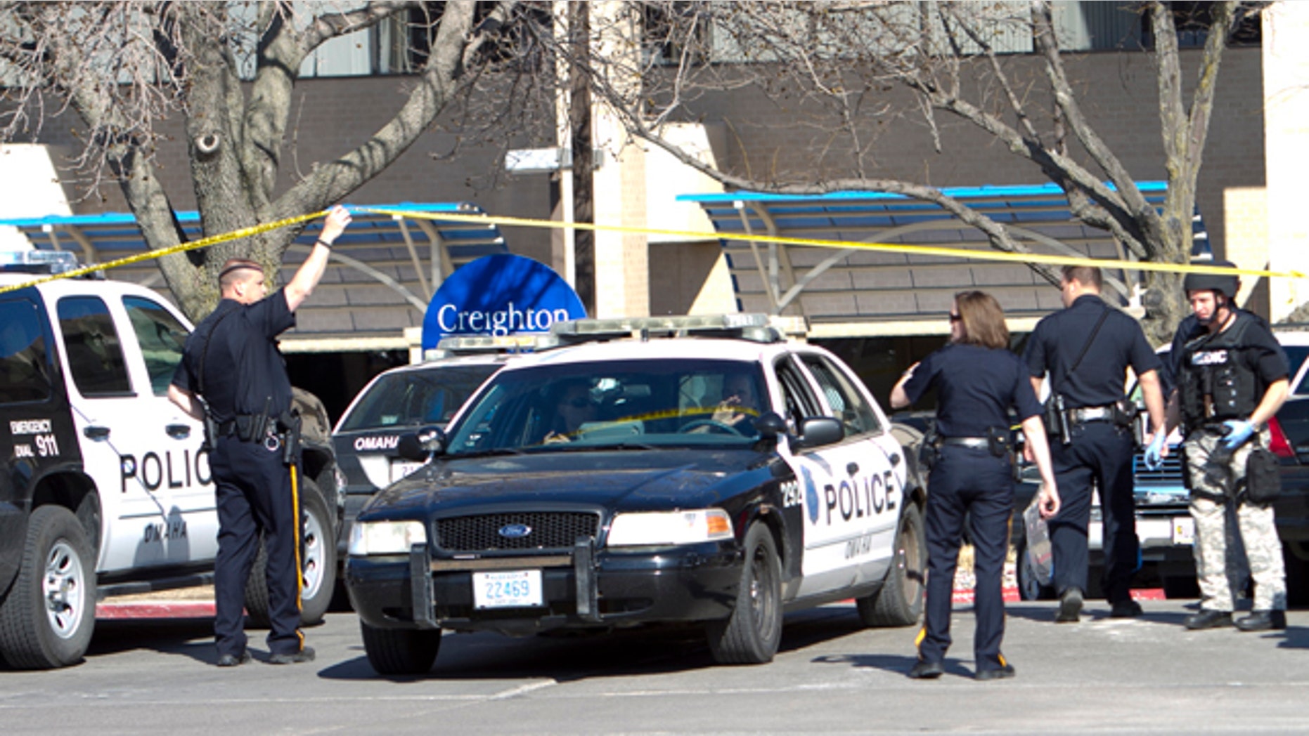 April 6, 2011: Police officers and vehicles work the scene in front of the Creighton University Medical Center, in Omaha, Neb., following a shooting inside the hospital. Omaha police have arrested a suspect.