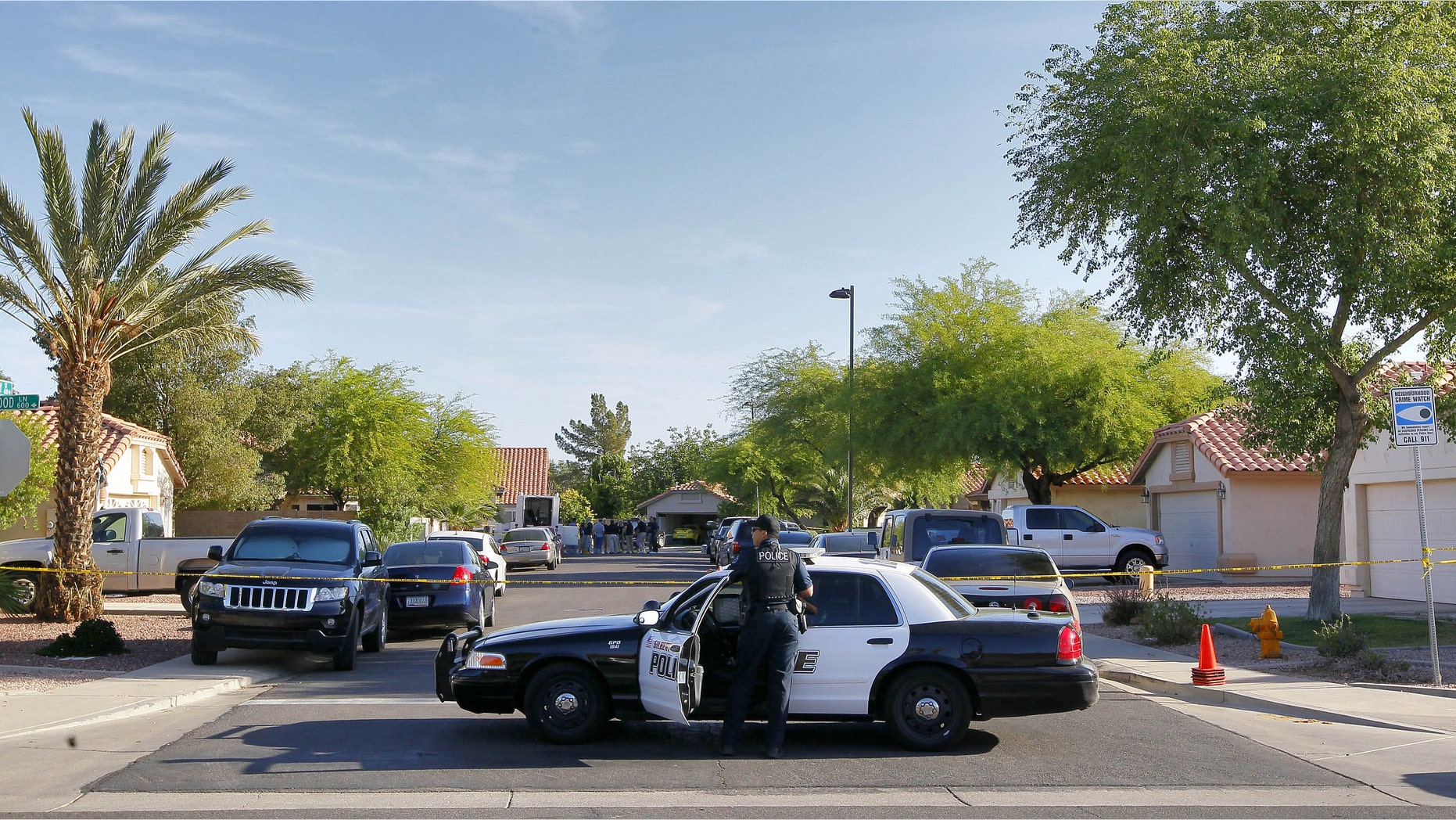 A Gilbert police officer blocks the street outside a shooting crime scene Thursday, May 3, 2012 in Gilbert, Ariz. (AP Photo/Matt York)