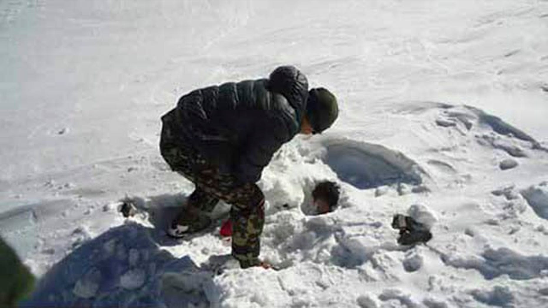 October 19, 2014: In this photo provided by the Nepalese army, a soldier searches for avalanche victims at Thorong La pass. (AP Photo/Nepalese Army)