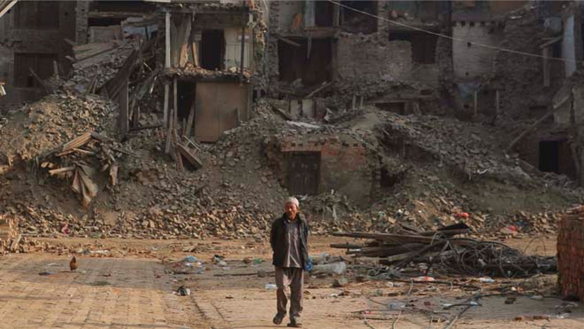 May 25, 2015: A Nepalese man walks past damaged houses one month after the deadly 7.8 magnitude earthquake in Kathmandu, Nepal.