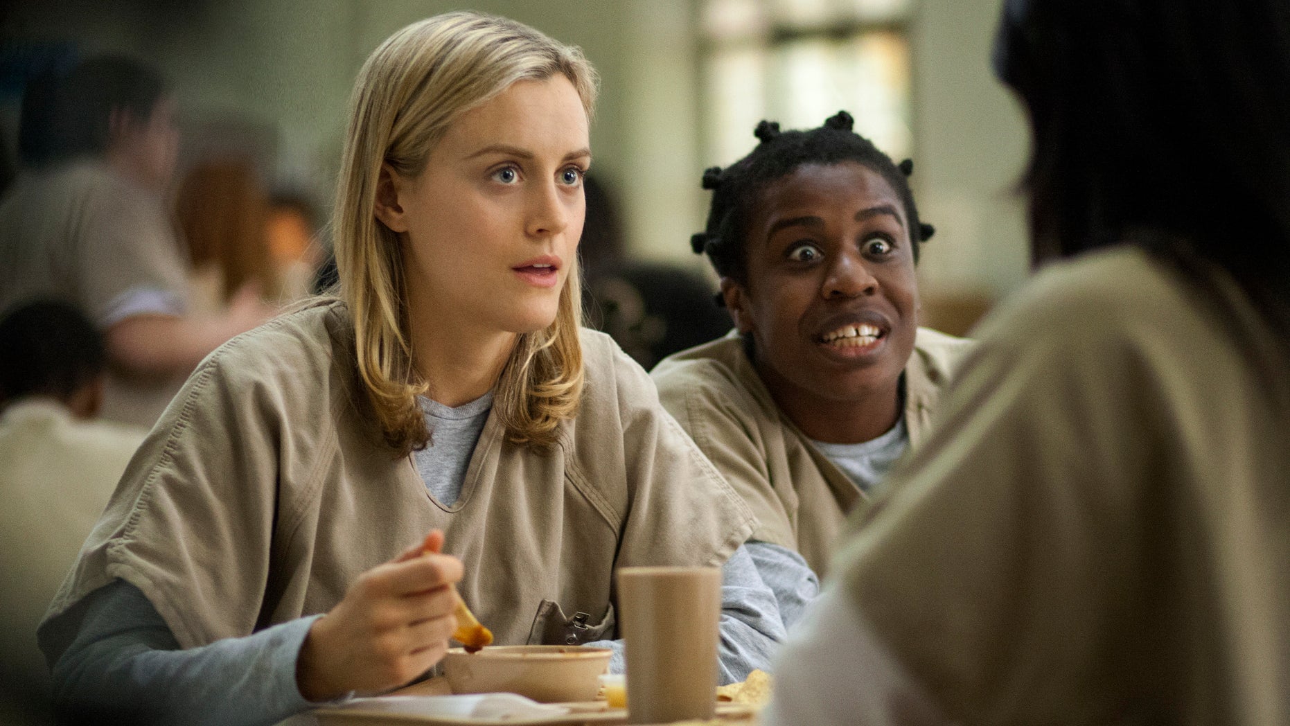 This image released by Netflix shows Taylor Schilling, left, and Uzo Aduba in a scene from 'Orange Is the New Black.'