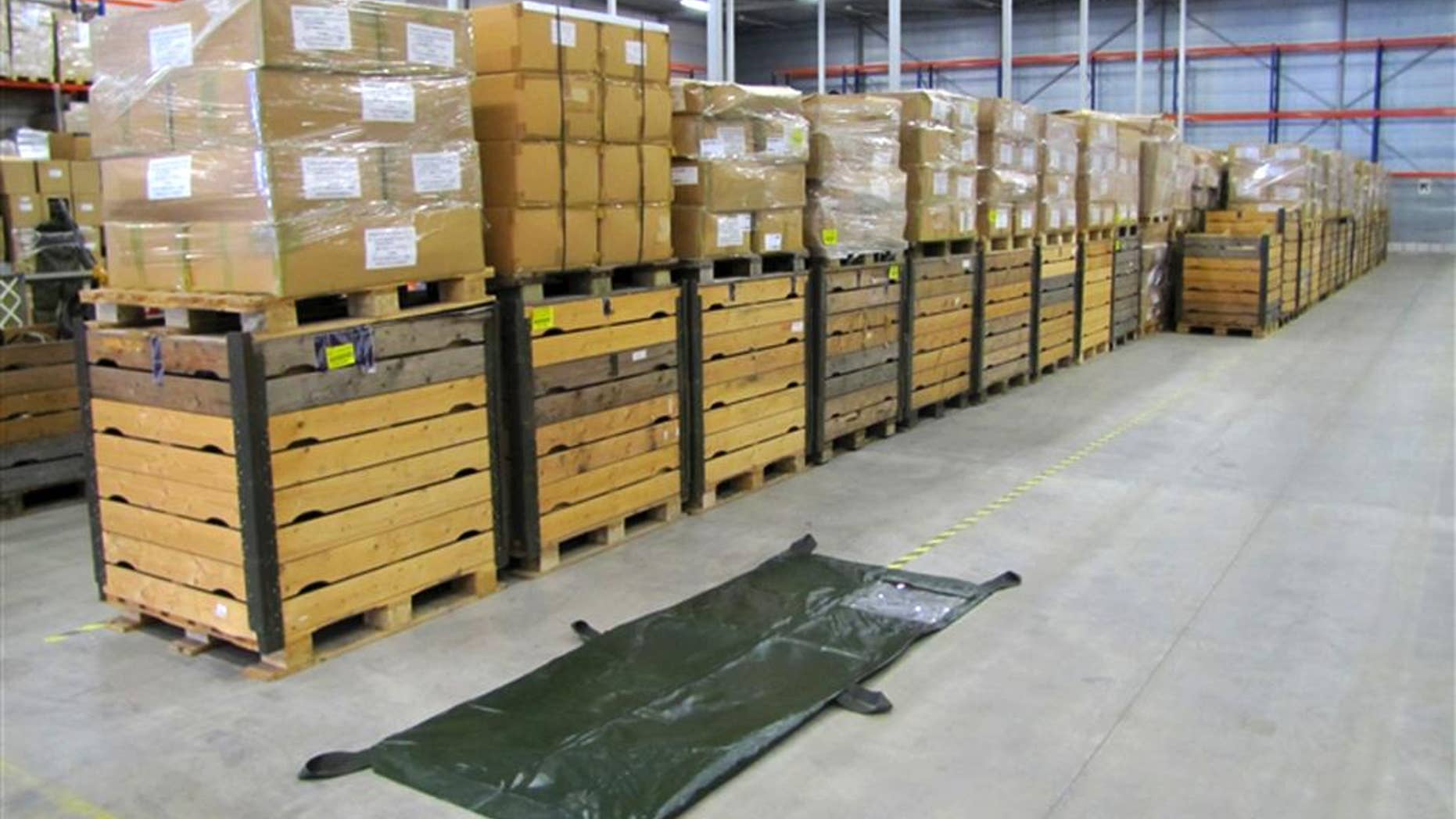 In this undated but recent handout photo provided by BVA-Auctions.com, a body bag is displayed next to pallets containing about 2500 body bags put up for auction by the Dutch government Thursday, Oct. 2, 2014. Call it an offer to die for. The government is selling off 2,500 body bags in an online auction. Rob Meijer, commercial director of BVA Auctions, said Thursday his company sells plenty of strange stuff, but "this is special." The bags are being sold in a single lot, which has a reserve price of 4,000 euros (usd 5,050). The auction closes on Oct. 6. (AP Photo/BVA-Auctions.com, HO)