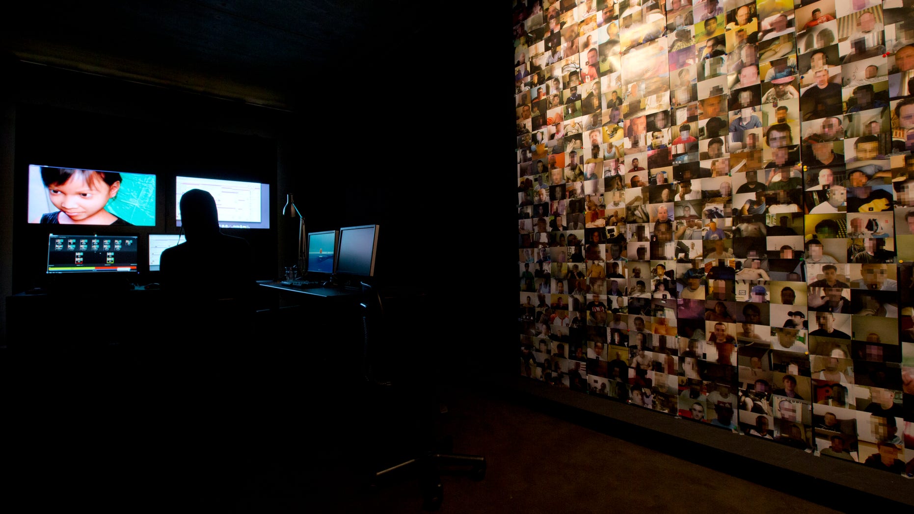 Nov. 4, 2013 - A wall is plastered with pictures of men suspected of soliciting underage girls for webcam sex while a Terre des Hommes researcher, center rear, takes the identity of fake 10-year-old Sweetie from the Philippines, in a computer-generated image.