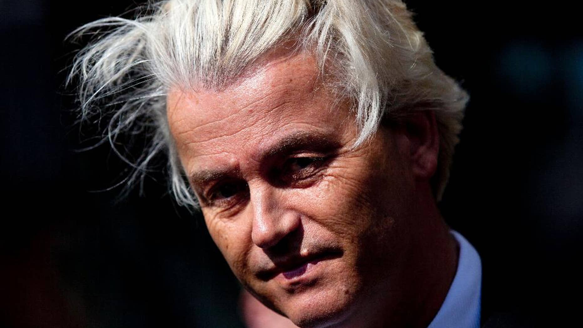 FILE - In this May 12, 2014 file photo Dutch lawmaker Geert Wilders pauses, as he speaks to journalists outside the Dutch National Bank in Amsterdam. Dutch authorities on Thursday, Dec. 18, 2014, said they will prosecute Wilders for hate speech over a chant in which he asked his supporters whether they wanted more or fewer Moroccans in the Netherlands and they shouted back “Fewer! Fewer! Fewer!” The announcement marks the second time Wilders has faced charges linked to his anti-immigrant and anti-Islam rhetoric. He was acquitted of similar charges in 2011 for comparing Islam with Naziism and calling for a ban on the Quran. (AP Photo/Peter Dejong, File)