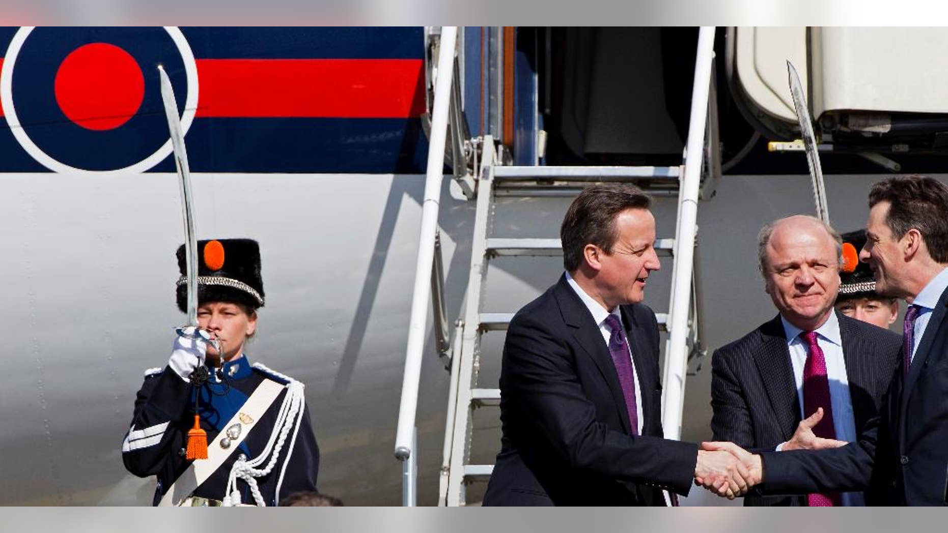 British Prime Minister David Cameron, center, arrives at Schiphol airport in Amsterdam on Monday March 24, 2014 ahead of the March 24-25 Nuclear Security Summit (NSS) in The Hague. (AP Photo/Martijn Beekman, POOL)