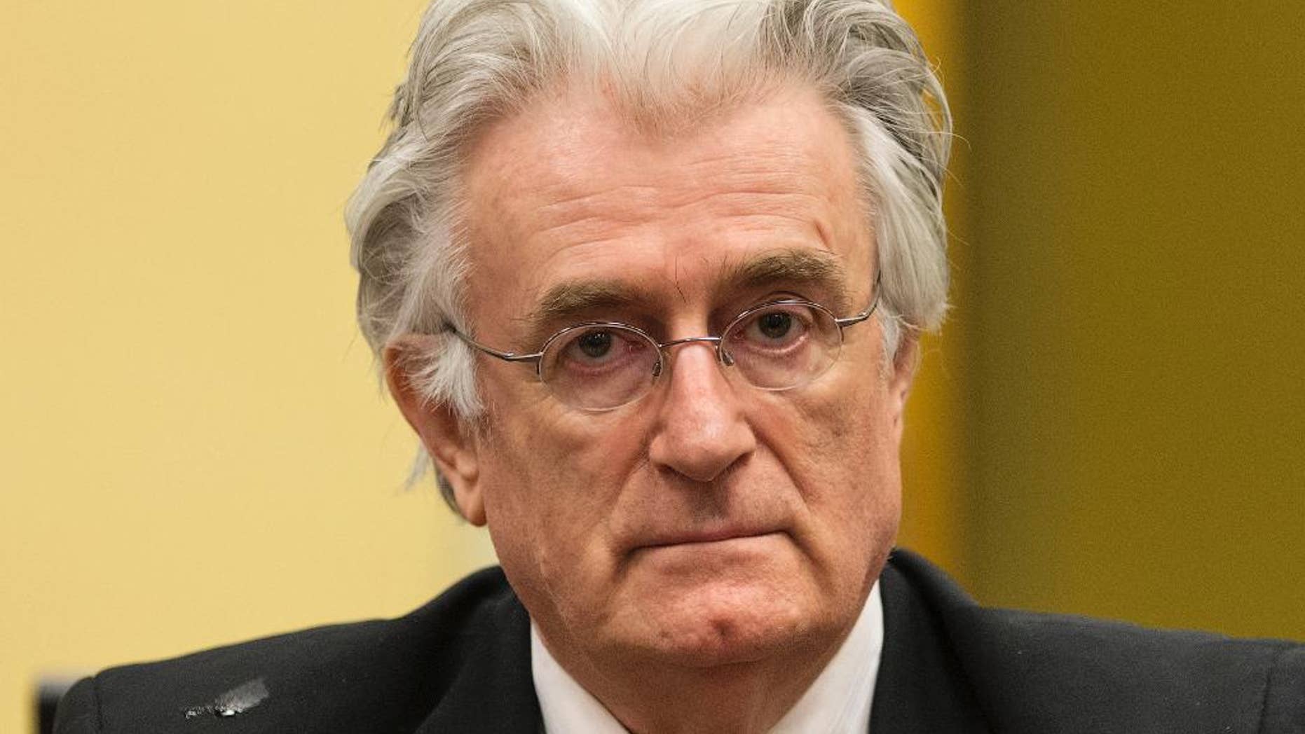 FILE - A Thursday, July 11, 2013 photo from files showing former Bosnian Serb leader Radovan Karadzic awaiting the start of his appeal at the courtroom of the U.N. Yugoslav war crimes tribunal (ICTY) in The Hague, Netherlands. Prosecutors called former Bosnian Serb political leader Radovan Karadzic a liar in closing remarks at his genocide trial, saying his denials of responsibility for atrocities committed on a massive scale while he was in charge lack any credibility. Prosecutor Alan Tieger said Karadzic, 69, should be imprisoned for life if found guilty. Karadzic says he is innocent of any wrongdoing and was unaware of the 1995 slaughter of more than 7,000 Muslim men and boys by Serb forces at Srebrenica, the worst massacre in Europe since World War II. (AP Photo/Michael Kooren, Pool, File)