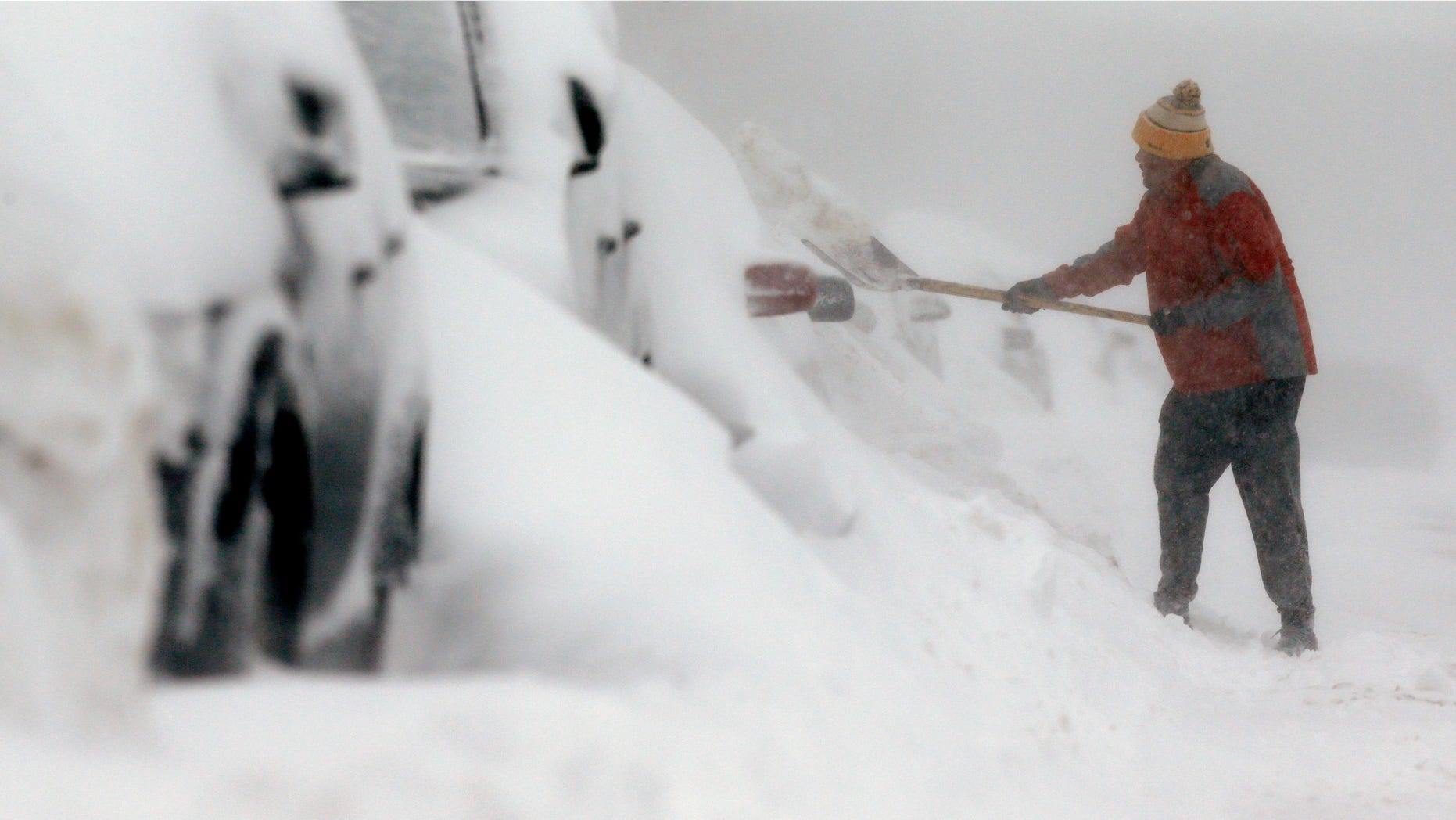 A man shovels snow in the East Boston neighborhood of Boston, Sunday, Feb. 15, 2015. A storm brought a new round of wind-whipped snow to New England on Sunday, threatening white-out conditions in coastal areas and forcing people to contend with a fourth winter onslaught in less than a month. (AP Photo/Michael Dwyer)