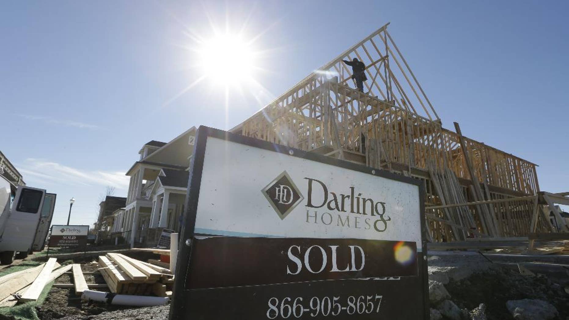 In this Dec. 15, 2014 photo, a sold sign sits in front of a house under construction in Coppell, Texas. The Commerce Department reports on sales of new homes in November on Tuesday, Dec. 23, 2014. (AP Photo/LM Otero)