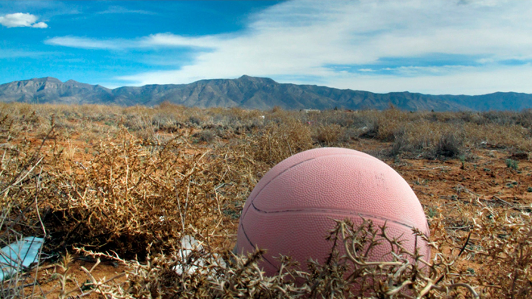 An old basketball in an abandon lot south of Albuquerque is shown where authorities say the body of a 12-year-old boy was discovered, Wednesday, Feb. 19, 2014, in Meadow Lake, N.M. Valencia County Sheriff Louis Burkhard said Alex Madrid of Albuquerque was found in the field Tuesday after his parents reported him missing.
(AP Photo/Russell Contreras)