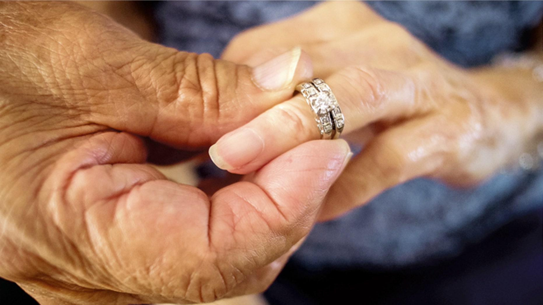 Robert Kirker puts a wedding ring, lost for 30 years, on his wife Ofelia's hand at their home in Las Cruces, N.M., May 27, 2015. (Jett Lowe/Las Cruces Sun-News via AP)