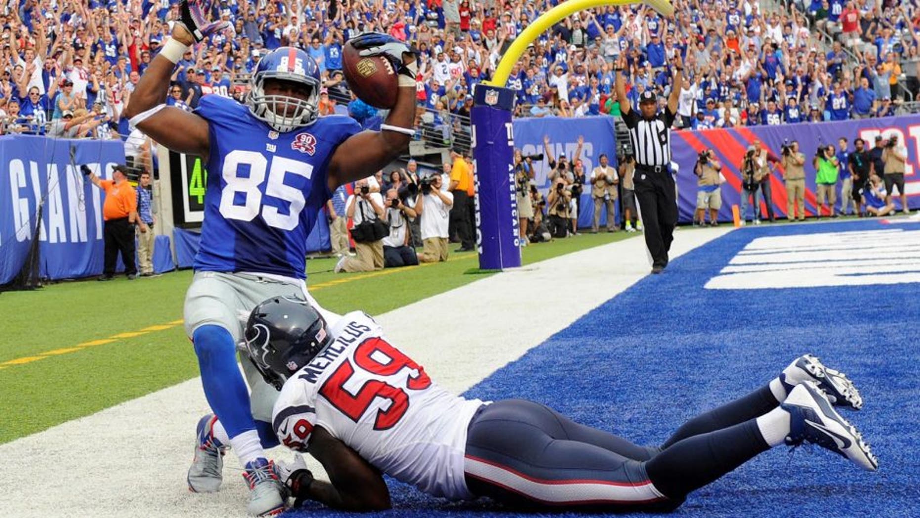 Sep 21, 2014; East Rutherford, NJ, USA; New York Giants tight end Daniel Fells (85) scores a touchdown against Houston Texans outside linebacker Whitney Mercilus (59) at MetLife Stadium. Mandatory Credit: Robert Deutsch-USA TODAY Sports